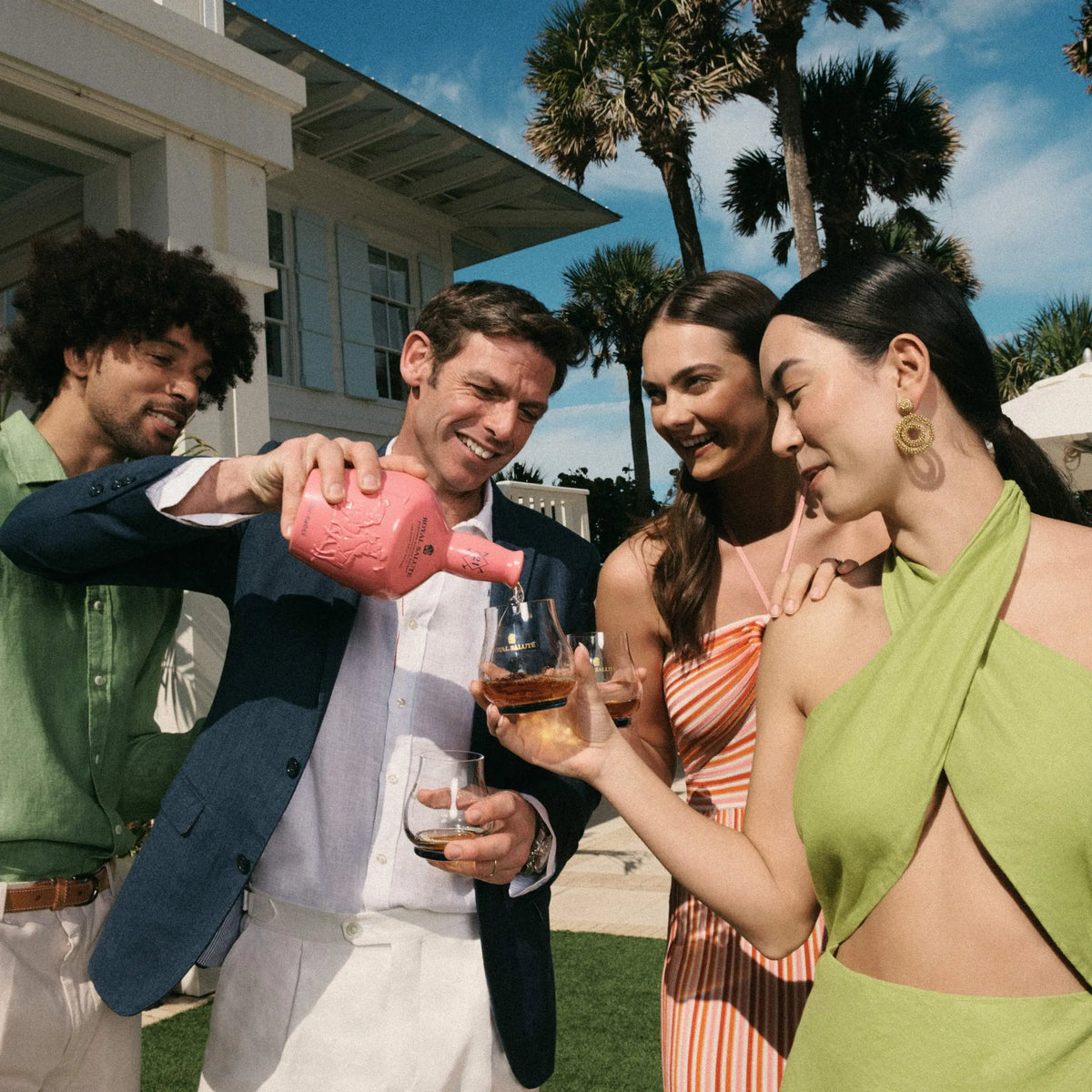 Group of friends enjoying Royal Salute whisky at a sunny Miami outdoor gathering.