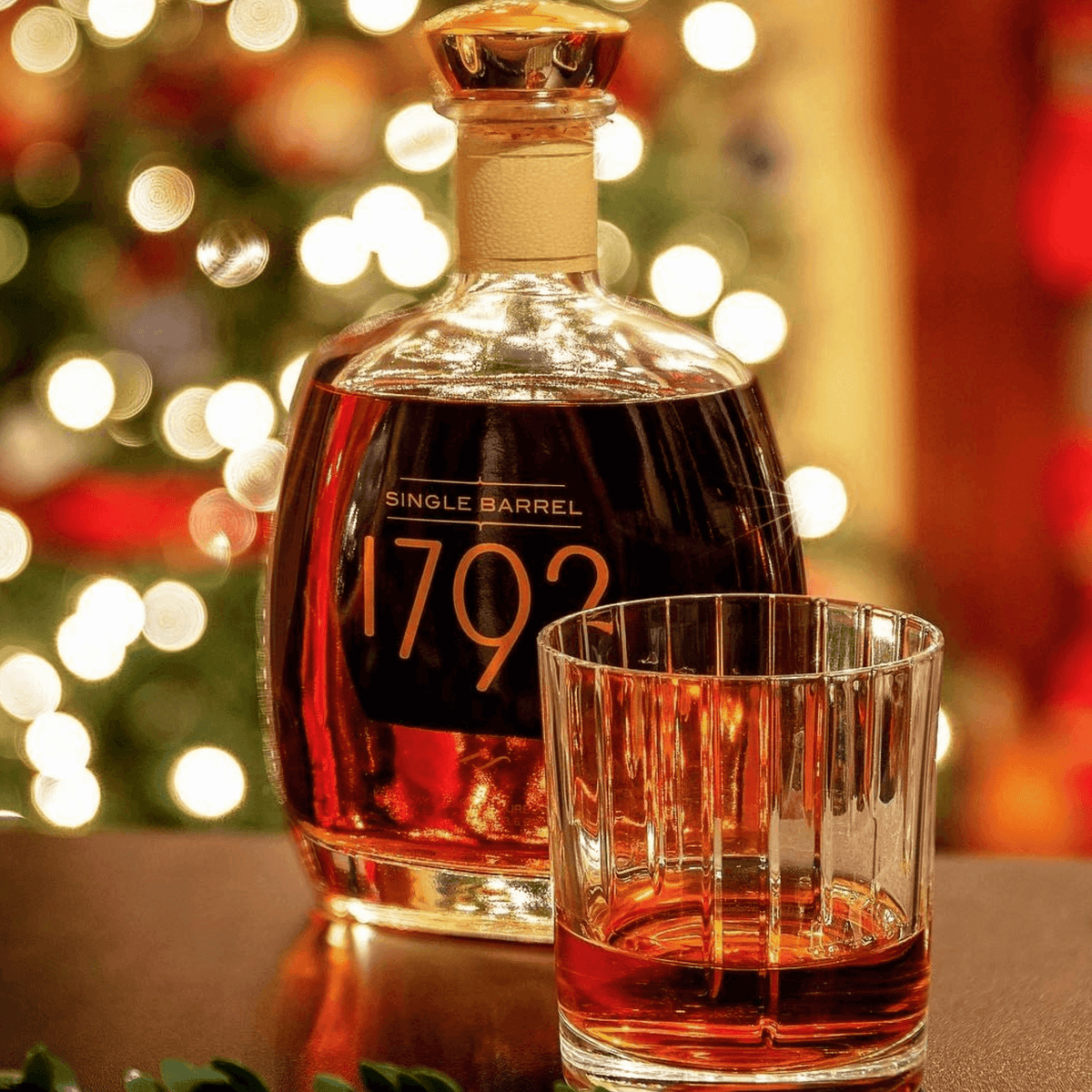 1792 Single Barrel Bourbon bottle beside a glass, set against a festive background of holiday lights.