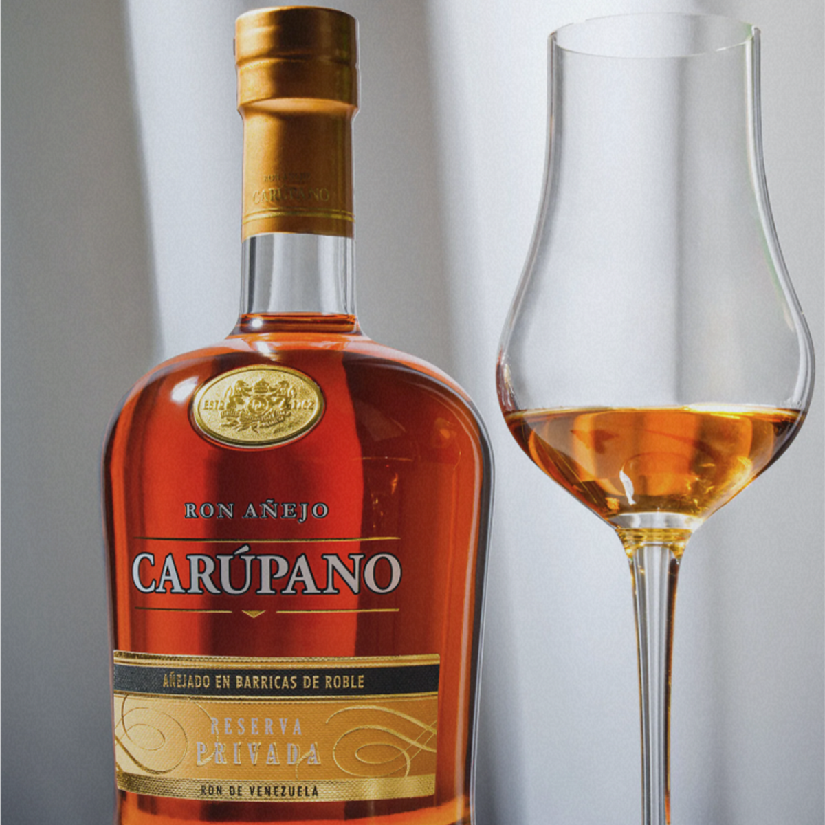 Ron Carupano Riserva Privada 21 Year Anejo Rum bottle with glass, showcasing its dark amber color and elegant design.