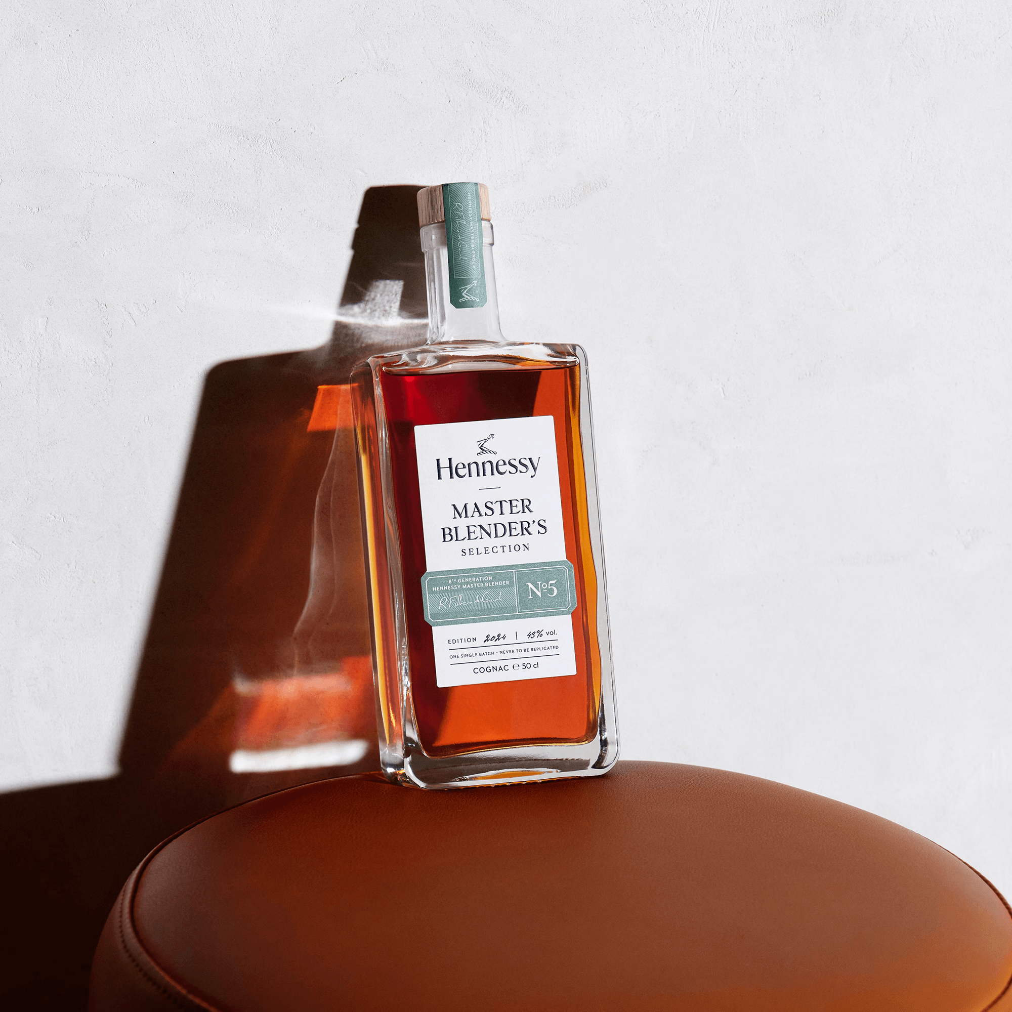 Hennessy Master Blender's Selection No. 5 Cognac bottle on a brown leather surface, showcasing craftsmanship and elegance.