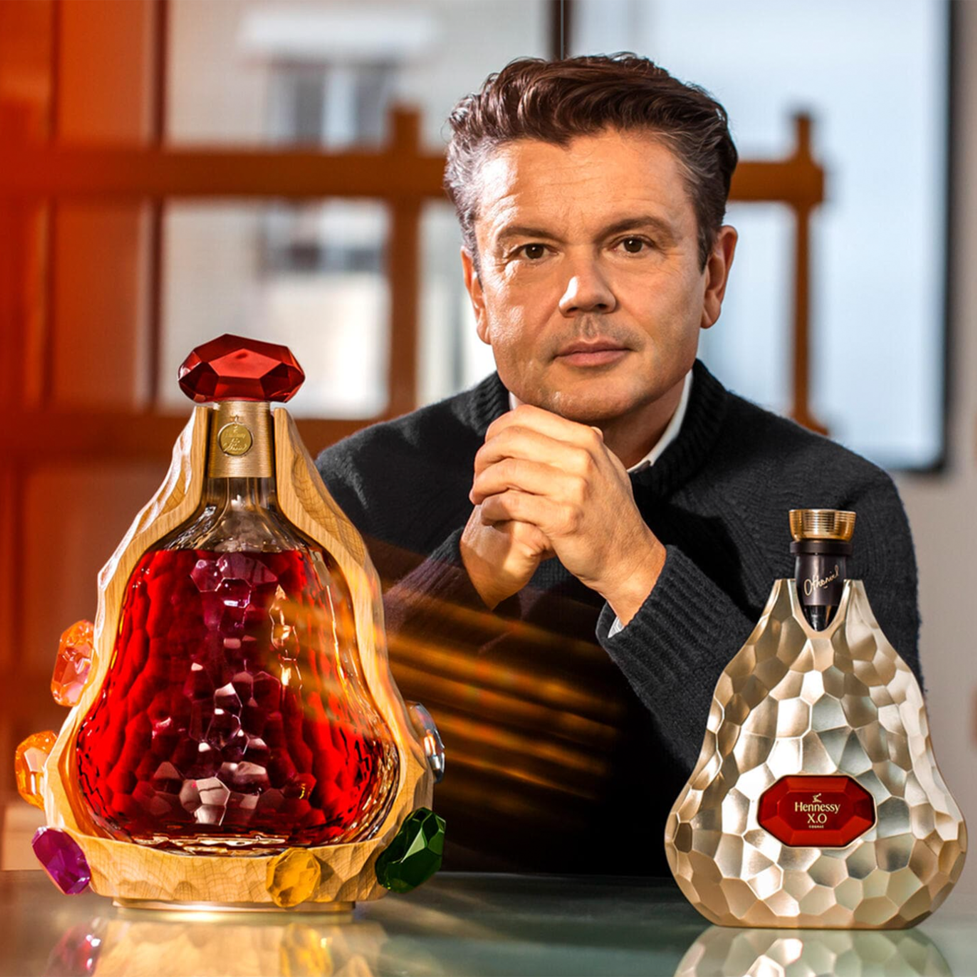 Hennessy x Jean-Michel Othoniel X.O. Cognac showcased with artist, featuring unique decanter design and vibrant colors.