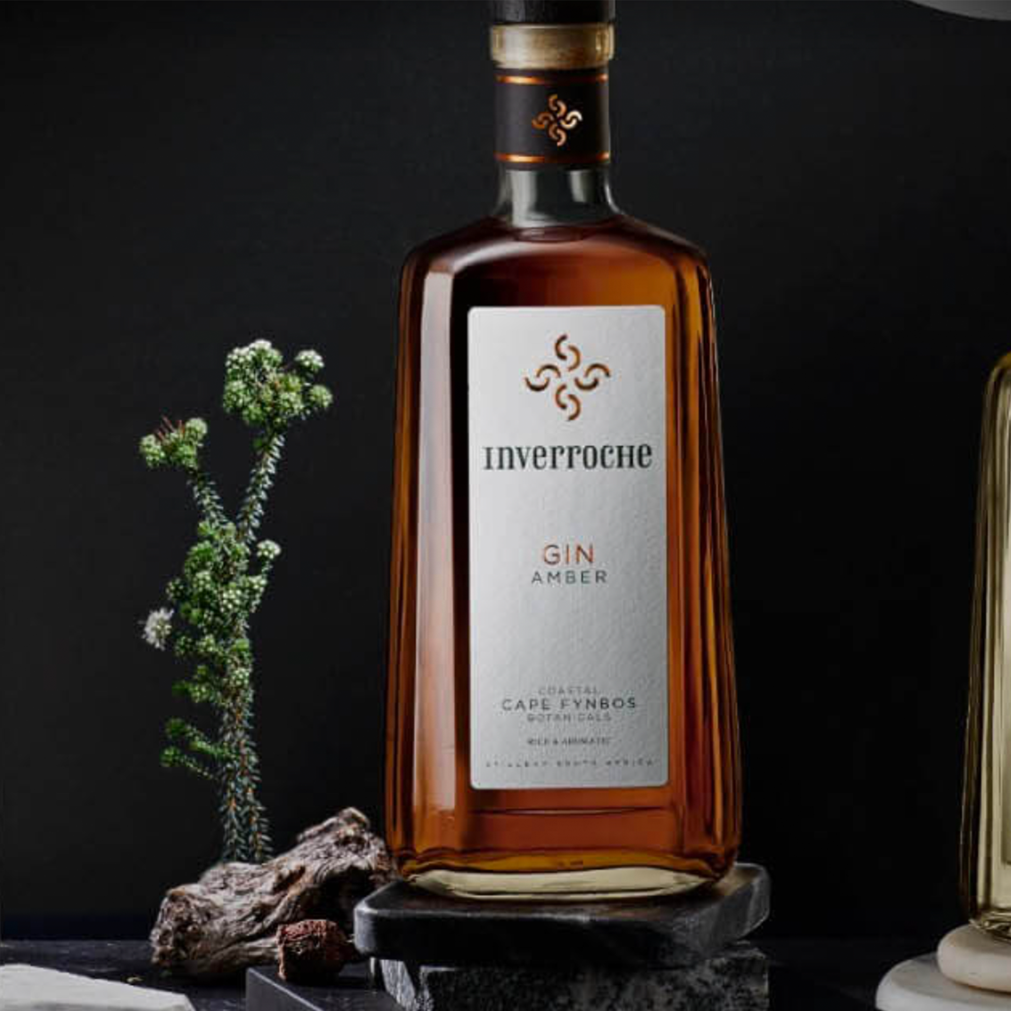 Inverroche Amber Craft Gin bottle with fynbos and natural stones, showcasing rich amber color and elegant design.