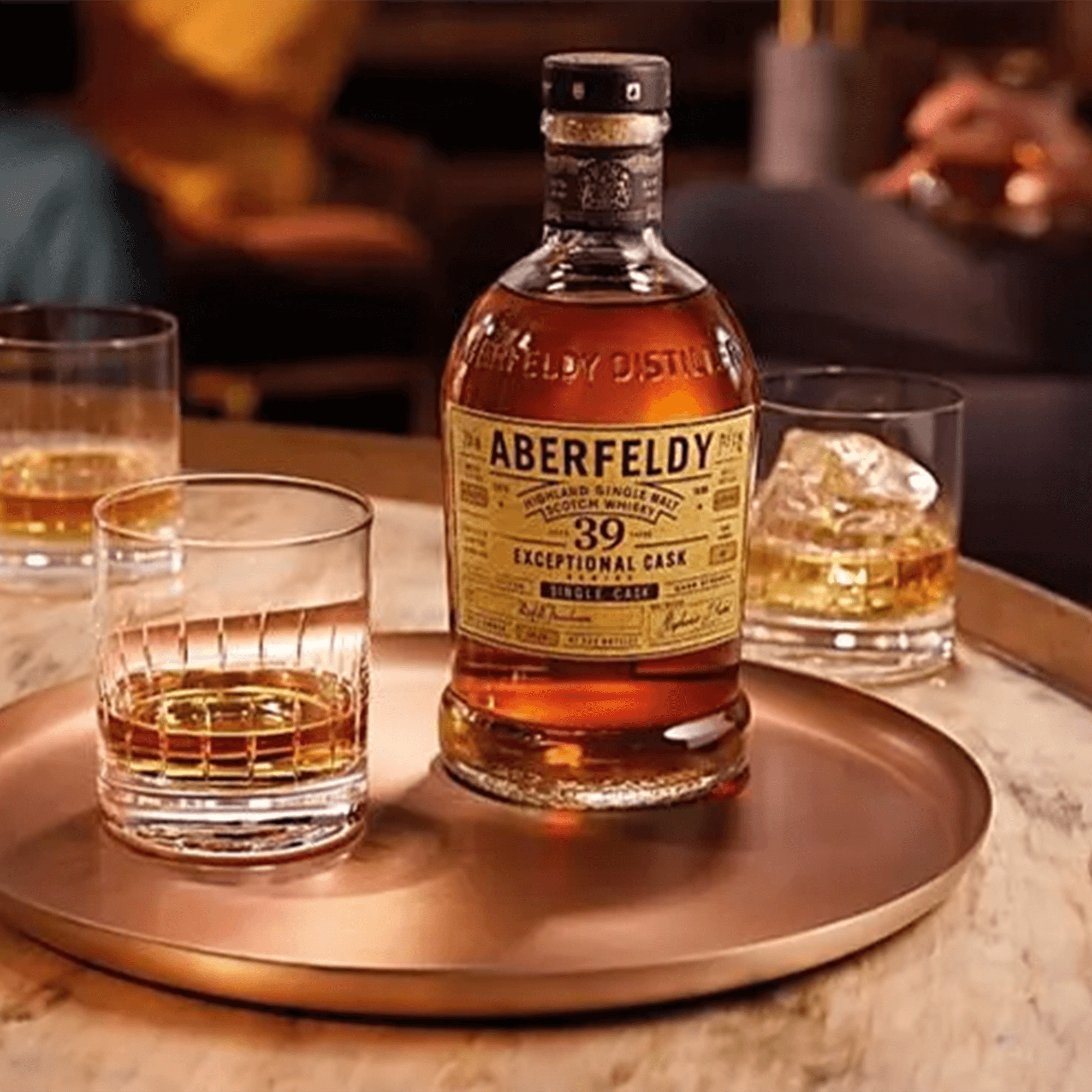 Aberfeldy 39 Year Exceptional Cask Single Malt Whisky bottle with two glasses on a copper tray.