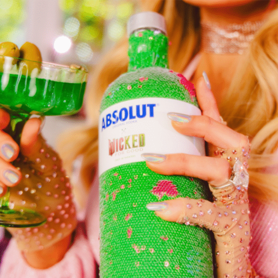 Absolut X Wicked Limited Edition Vodka in hand with green drink, showcasing the collectible sequin design.