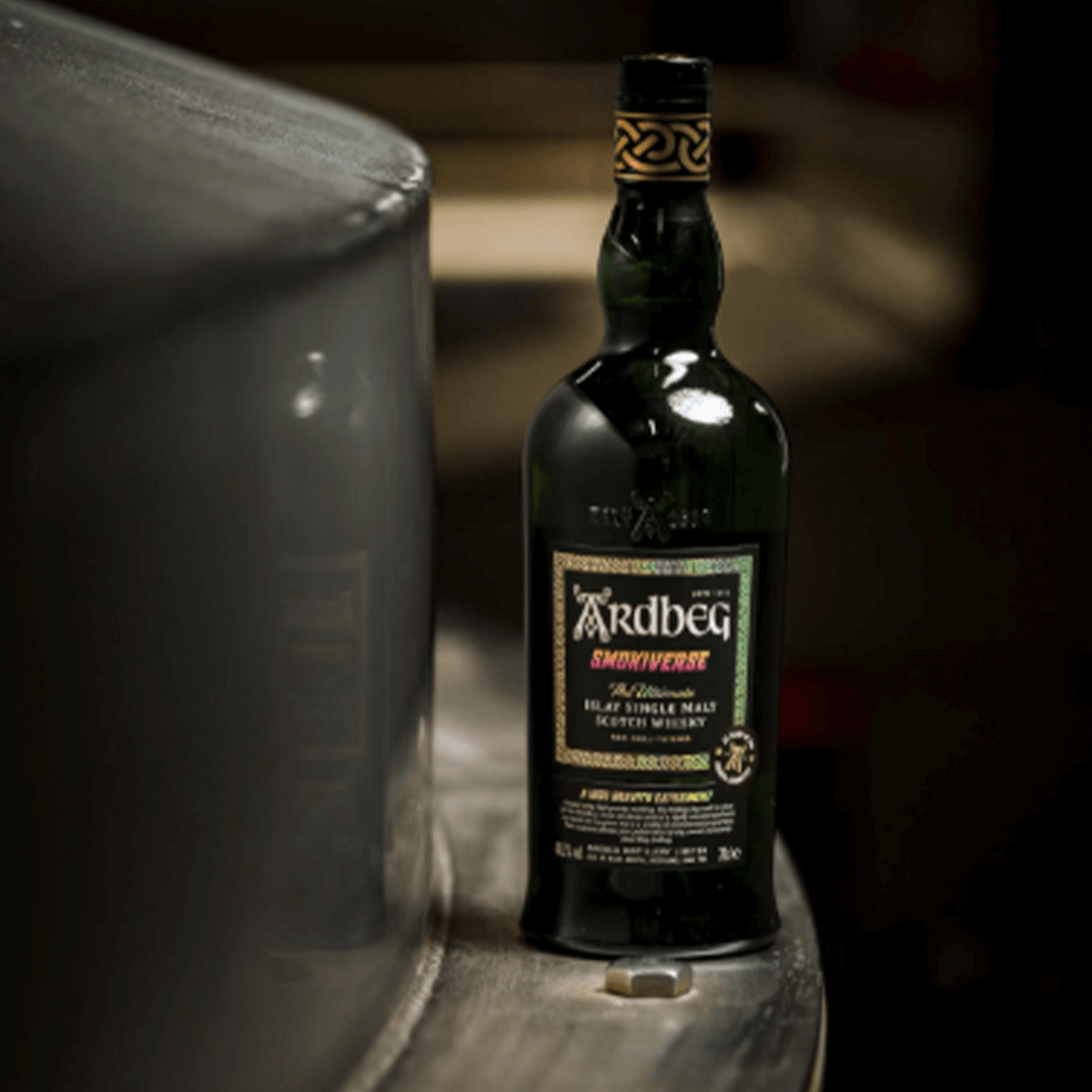 Ardbeg Smokiverse Islay Single Malt Scotch bottle on wooden barrel, celebrating whisky craftsmanship.