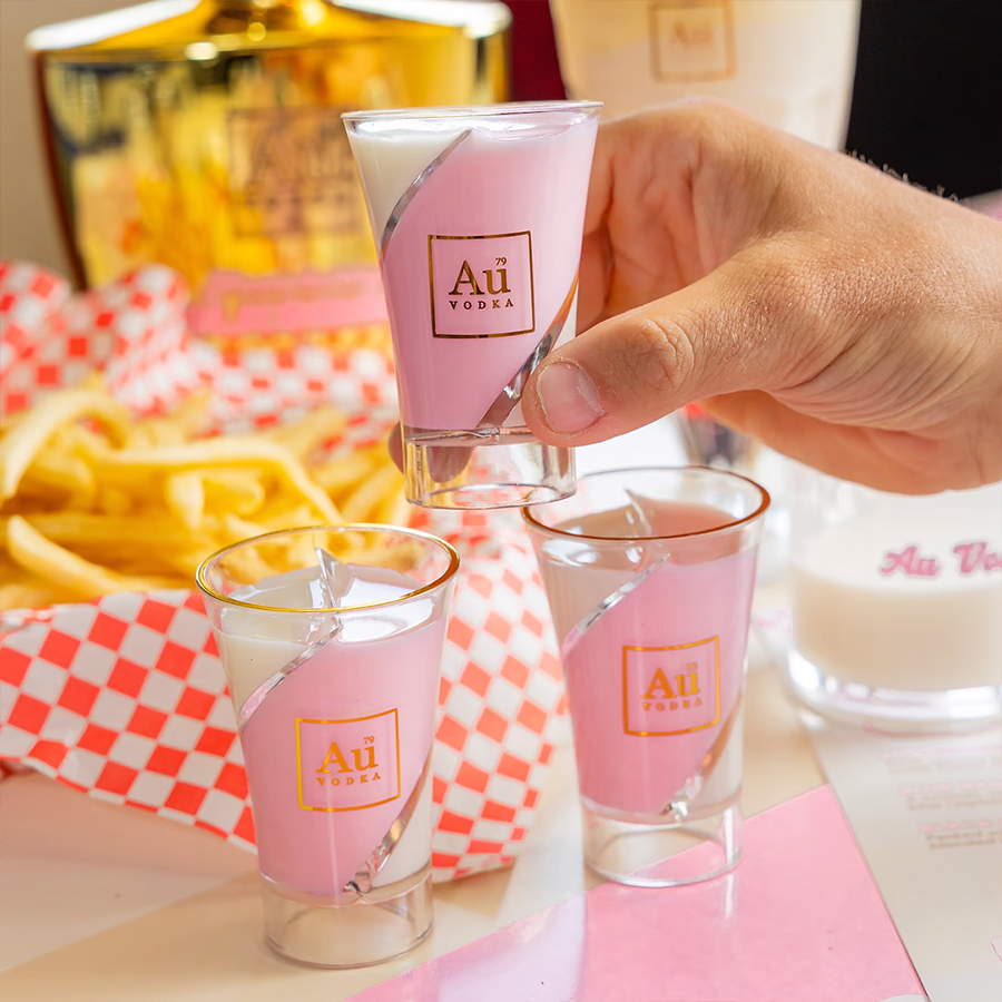 Au Vodka Strawberry Milkshake Liqueur shots served with fries on a table.