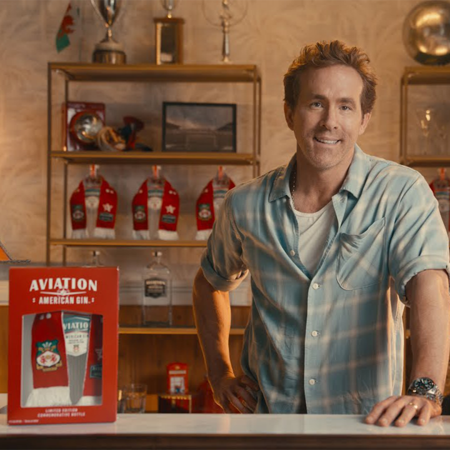 Aviation Gin Wrexham AFC Scarf Gift Set displayed with a smiling man in a bar setting.