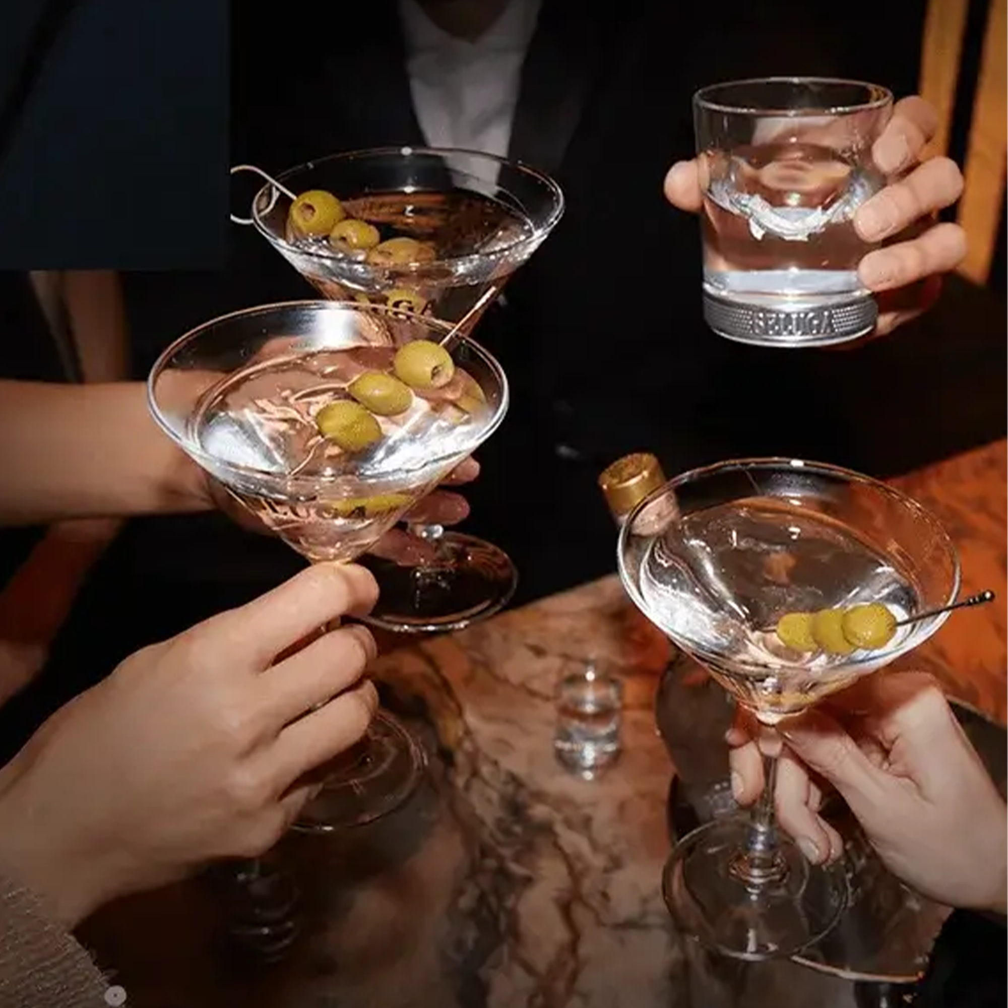 Group of friends toasting with martinis and drinks, showcasing a festive gathering.