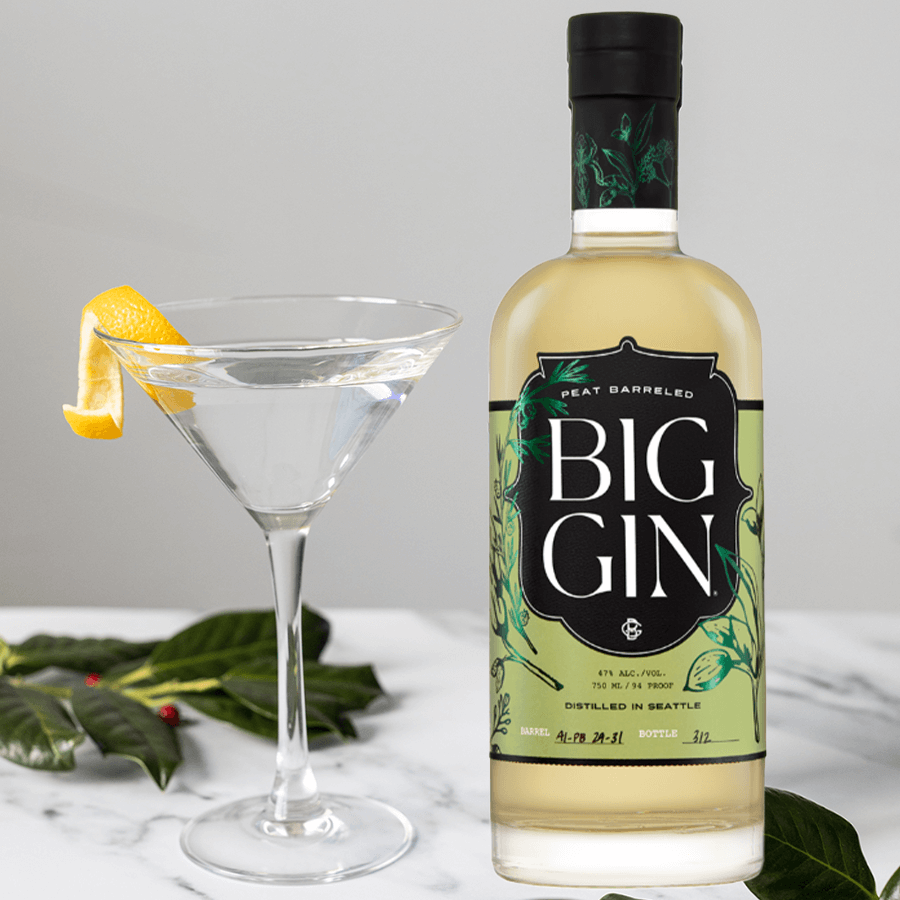 Bottle of Big Gin Peated Barreled beside a cocktail in a glass, showcasing its unique flavor profile.