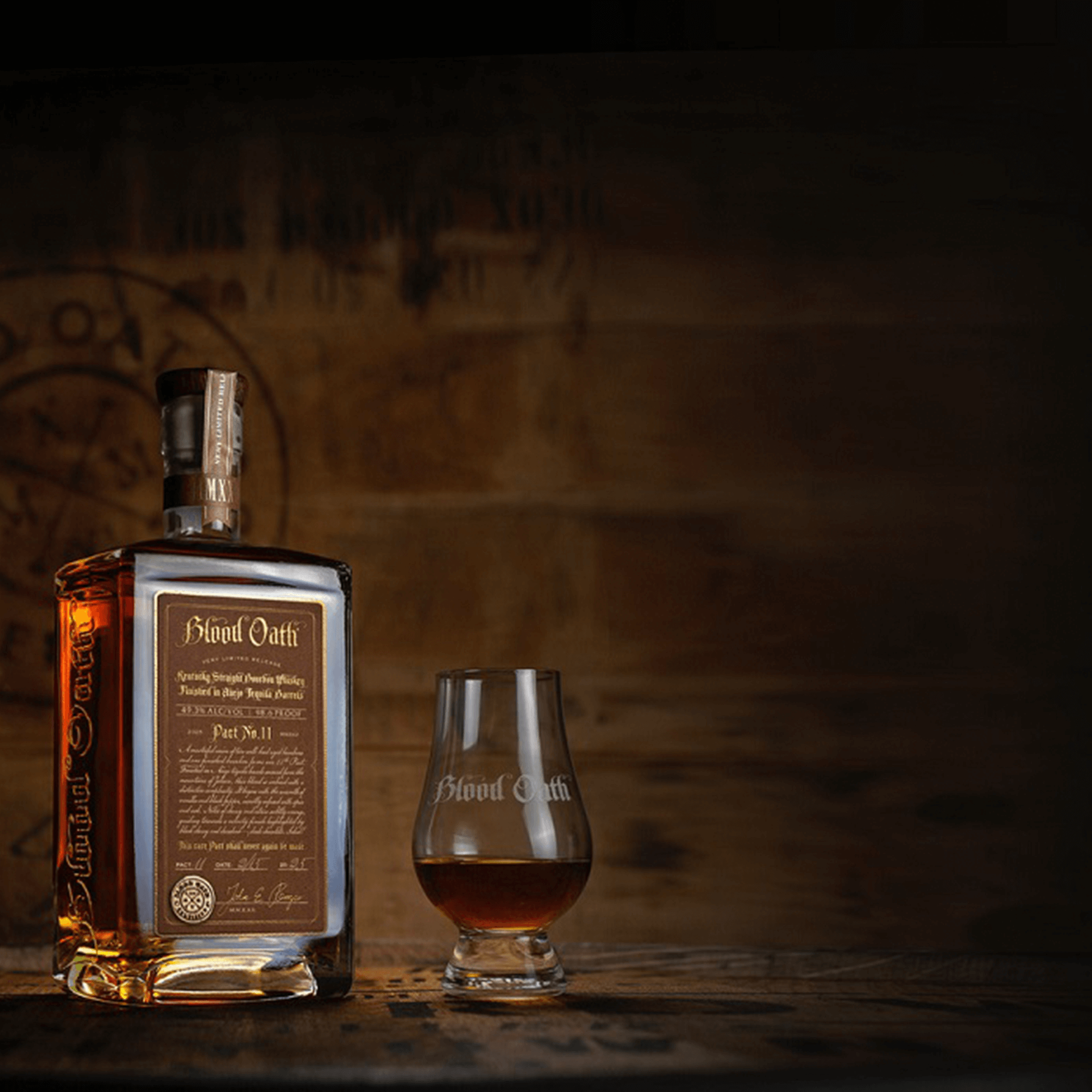 Bottle of Blood Oath Pact No. 11 Limited Edition Bourbon with a glass of whiskey, showcasing its rich color and unique label.
