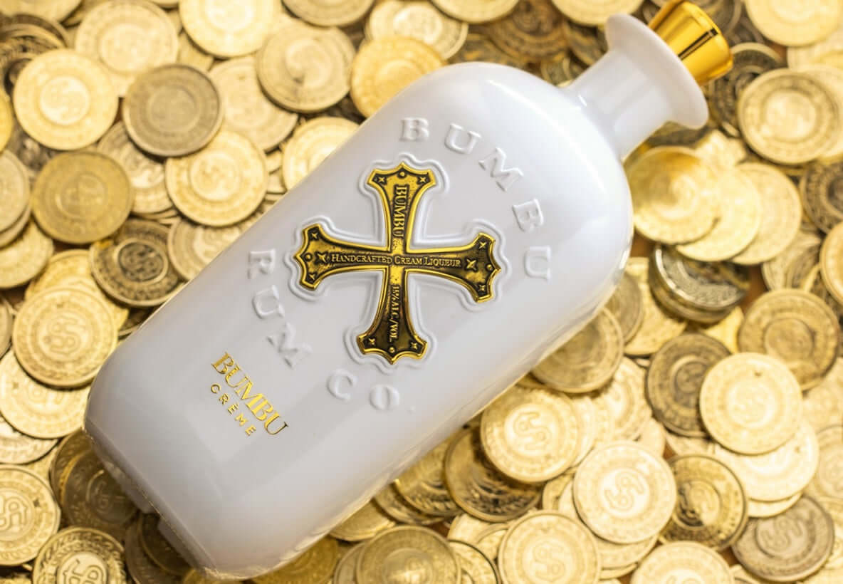 Bumbu Crème Rum bottle with gold coins, showcasing its craft rum and decadent dairy cream blend.