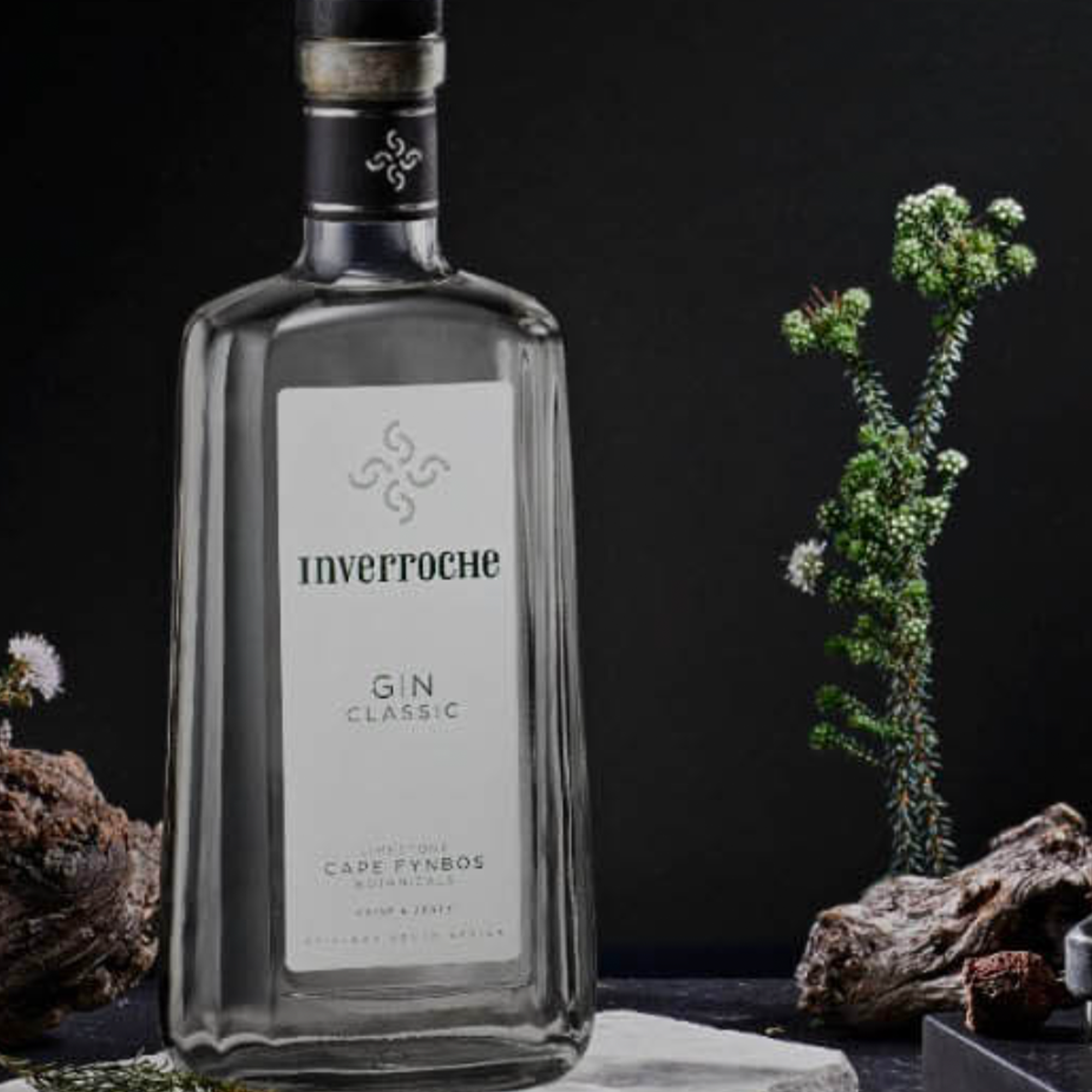 Inverroche Classic Craft Gin bottle with fynbos and natural elements on a dark background.