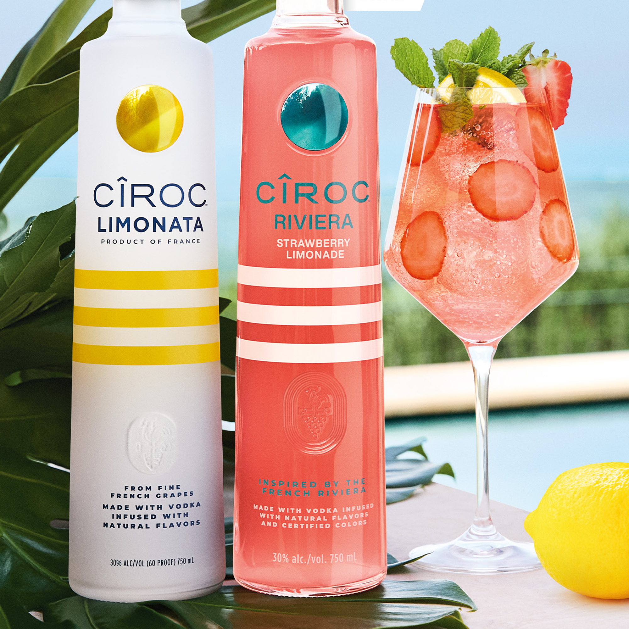 Cîroc Strawberry Limonade and Limonata vodka bottles with fresh strawberries and lemonade cocktail in a summer setting.