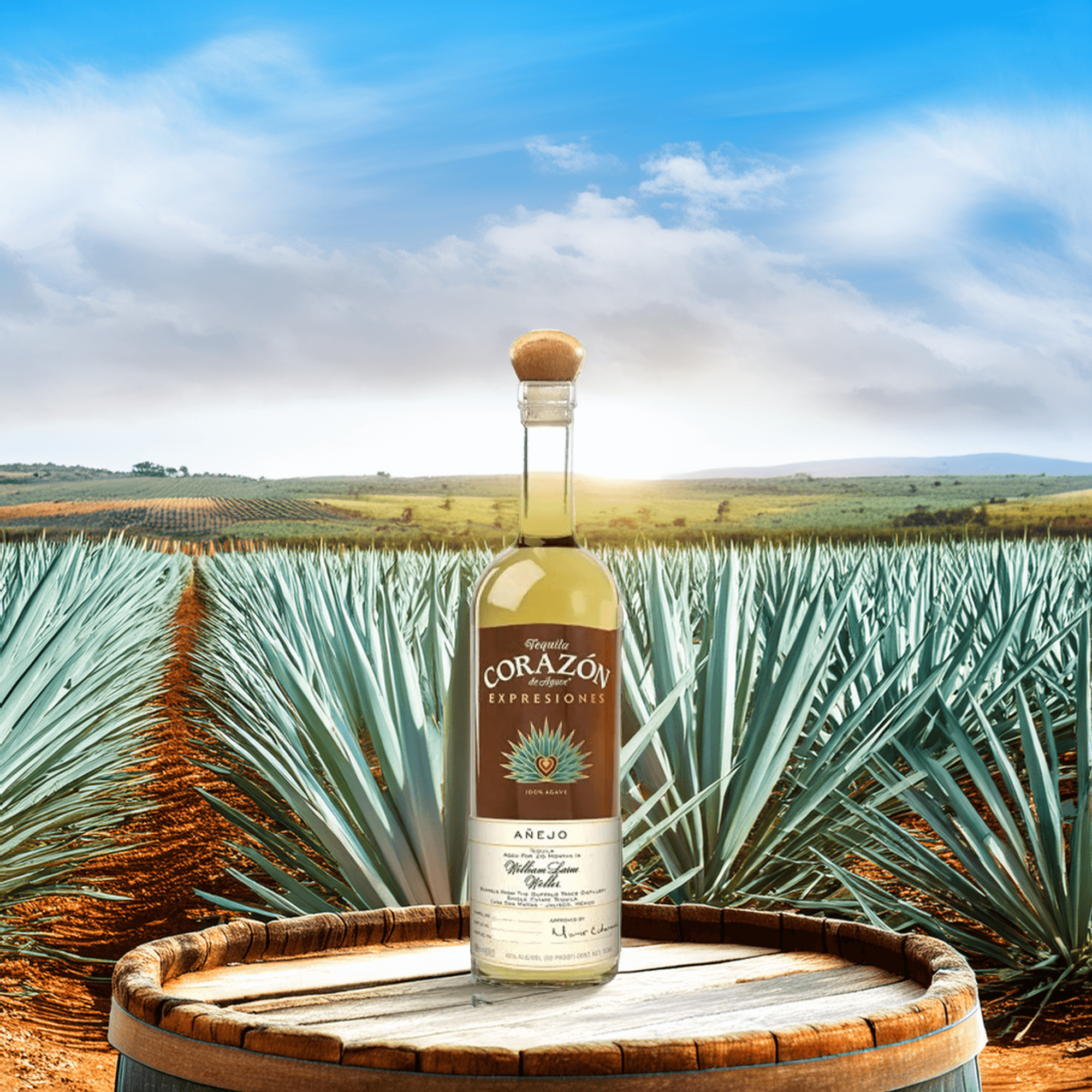 Corazón Expresiones Añejo Tequila bottle displayed on a barrel with agave fields and blue skies in the background.