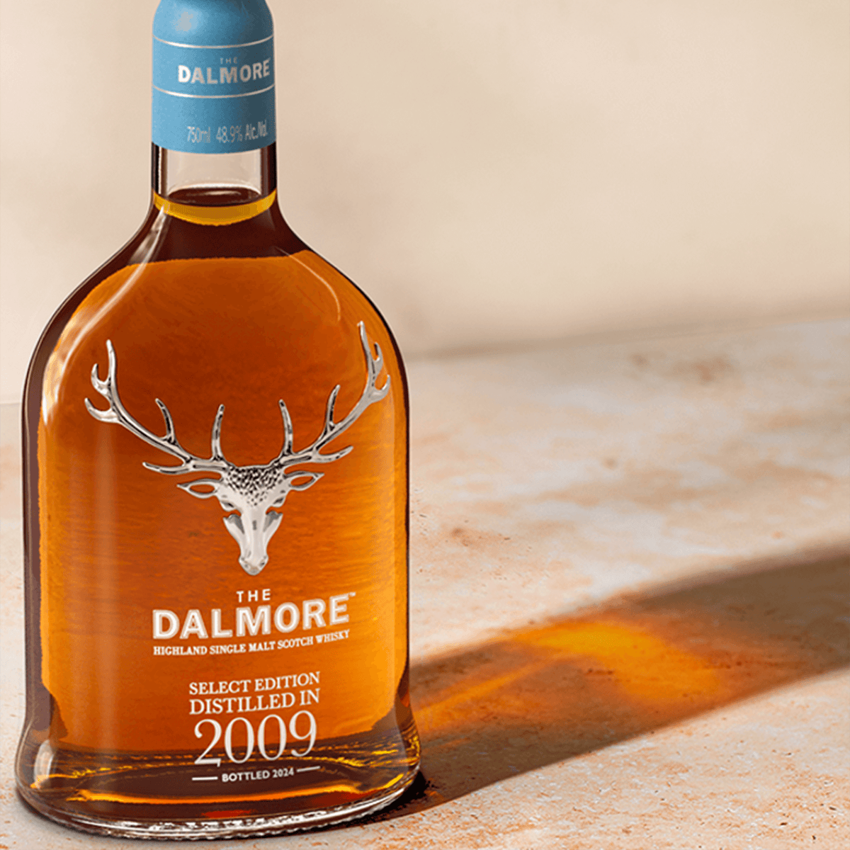 Dalmore 2009 Select Edition 15 Year Single Malt Scotch bottle on a stone surface, showcasing its rich amber color.