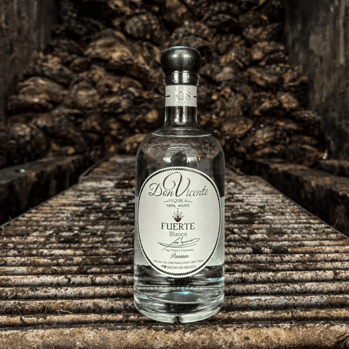 Don Vicente Fuerte Blanco Tequila bottle on rustic wooden rack, showcasing artisanal craftsmanship and clear liquid.