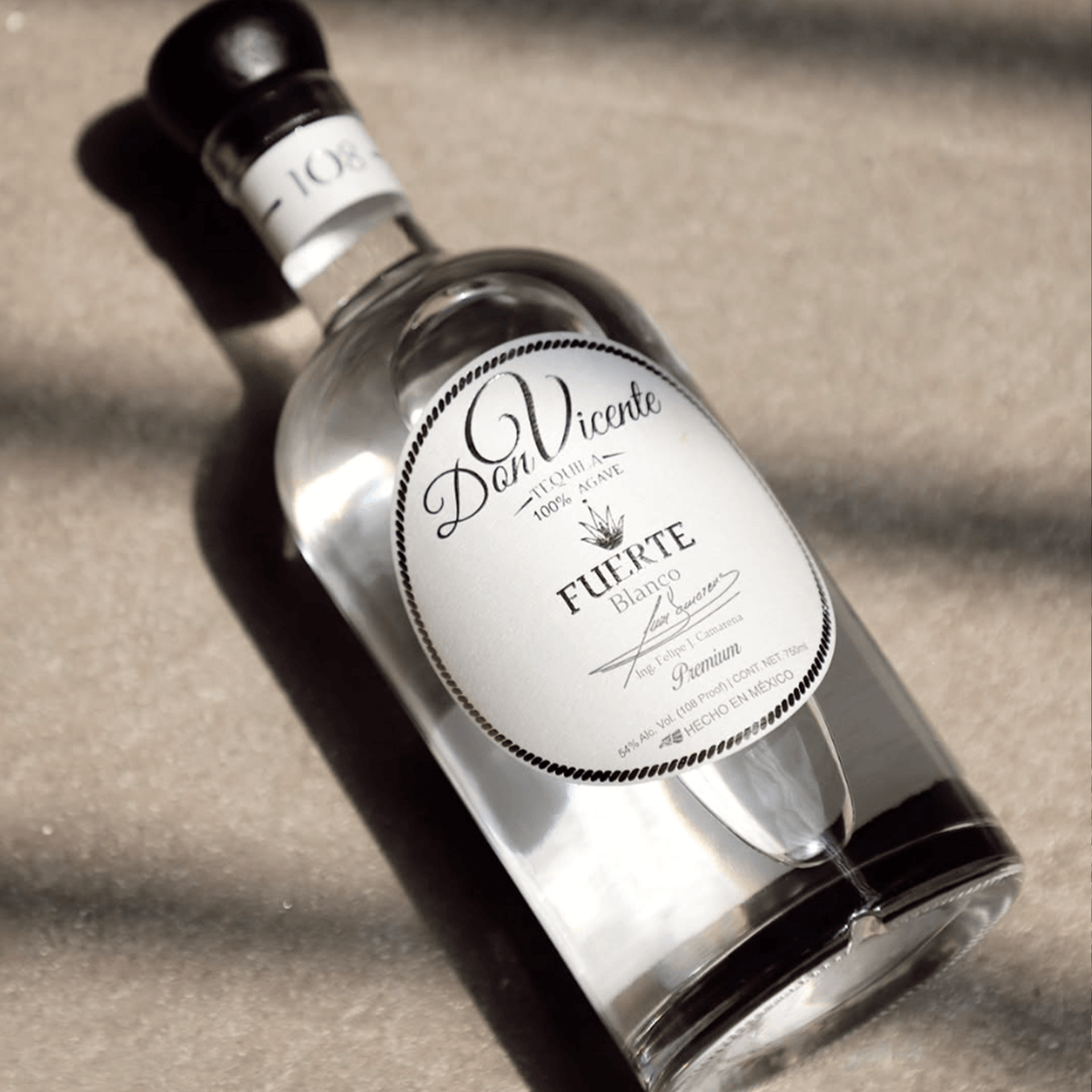 Don Vicente Fuerte Blanco Tequila bottle on a sandy surface highlighting its artisanal design and premium quality.
