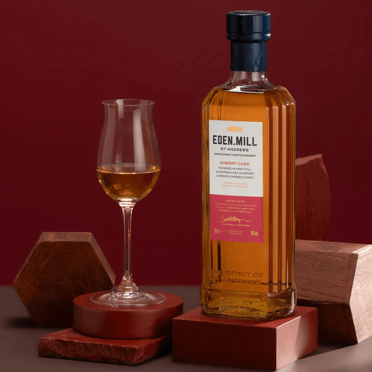 Eden Mill Bourbon Cask Single Malt Scotch 700ml with a glass, showcasing its rich amber color and elegant bottle design.