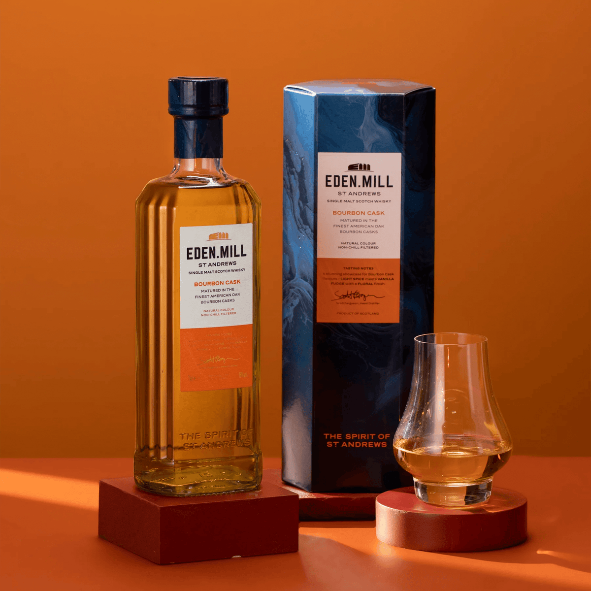 Eden Mill Bourbon Cask Single Malt Scotch bottle with packaging and glass, showcasing its rich golden color.