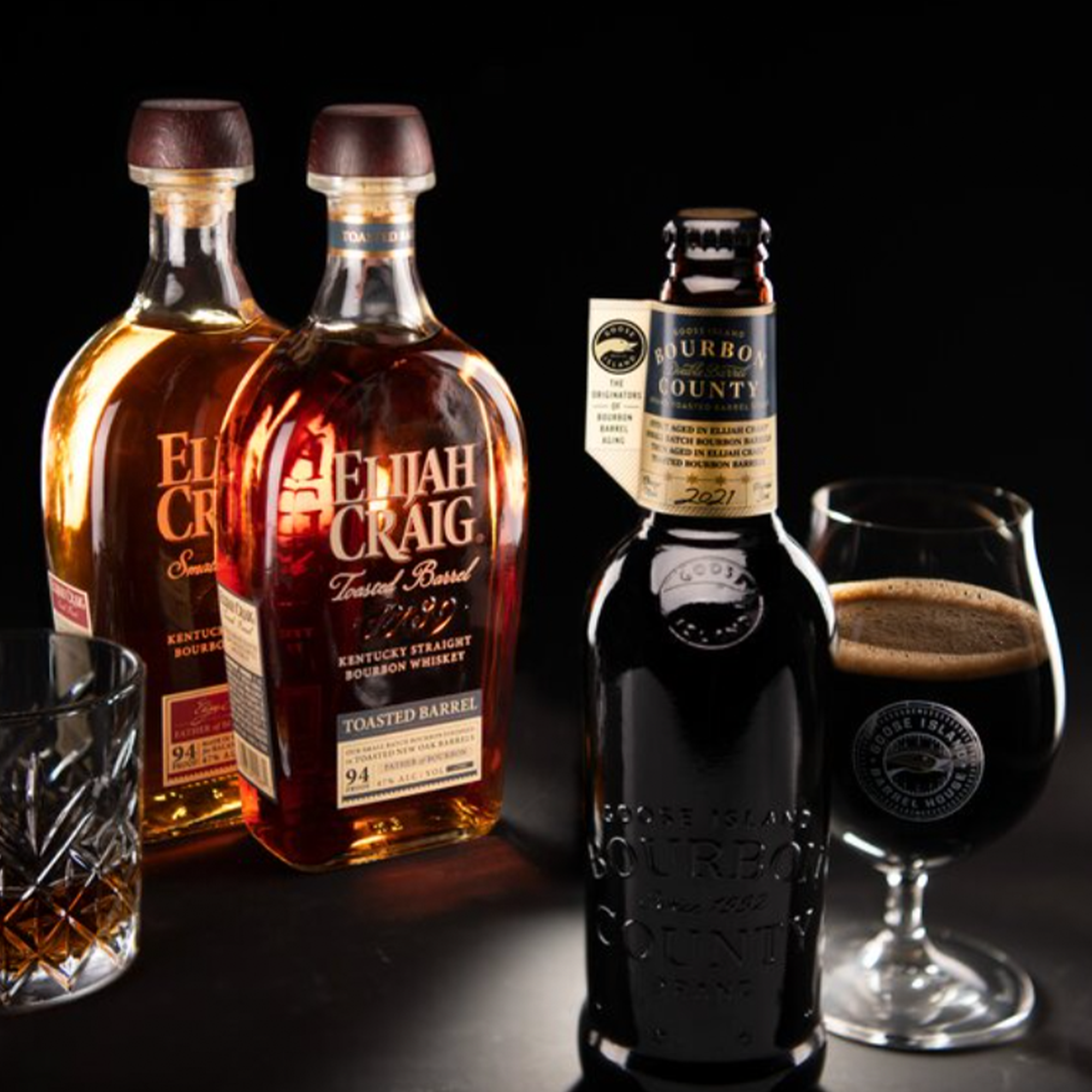 Goose Island Bourbon County stout with Elijah Craig toasted barrels and a whiskey glass on a dark background.