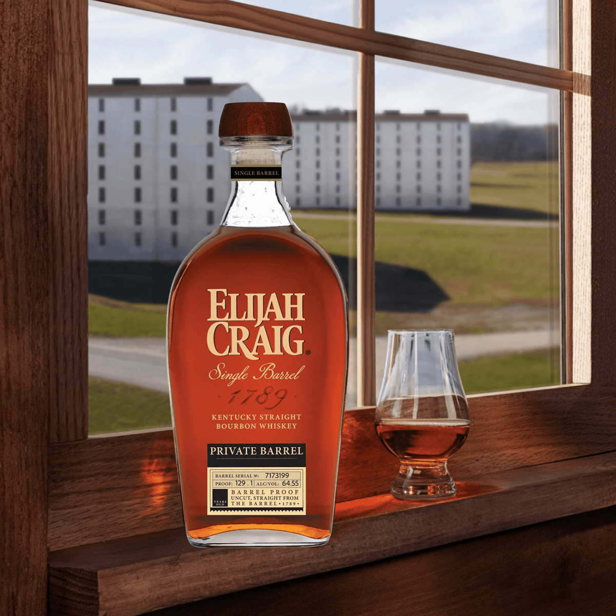 Elijah Craig Private Barrel No. 7173199 bourbon whiskey in a glass by the window, showcasing craftsmanship and rich flavor.