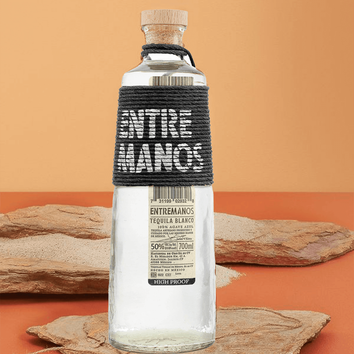 Entremanos High Proof Blanco Tequila 700ml bottle with coconut fiber wrap and cork stopper on an earthy background.