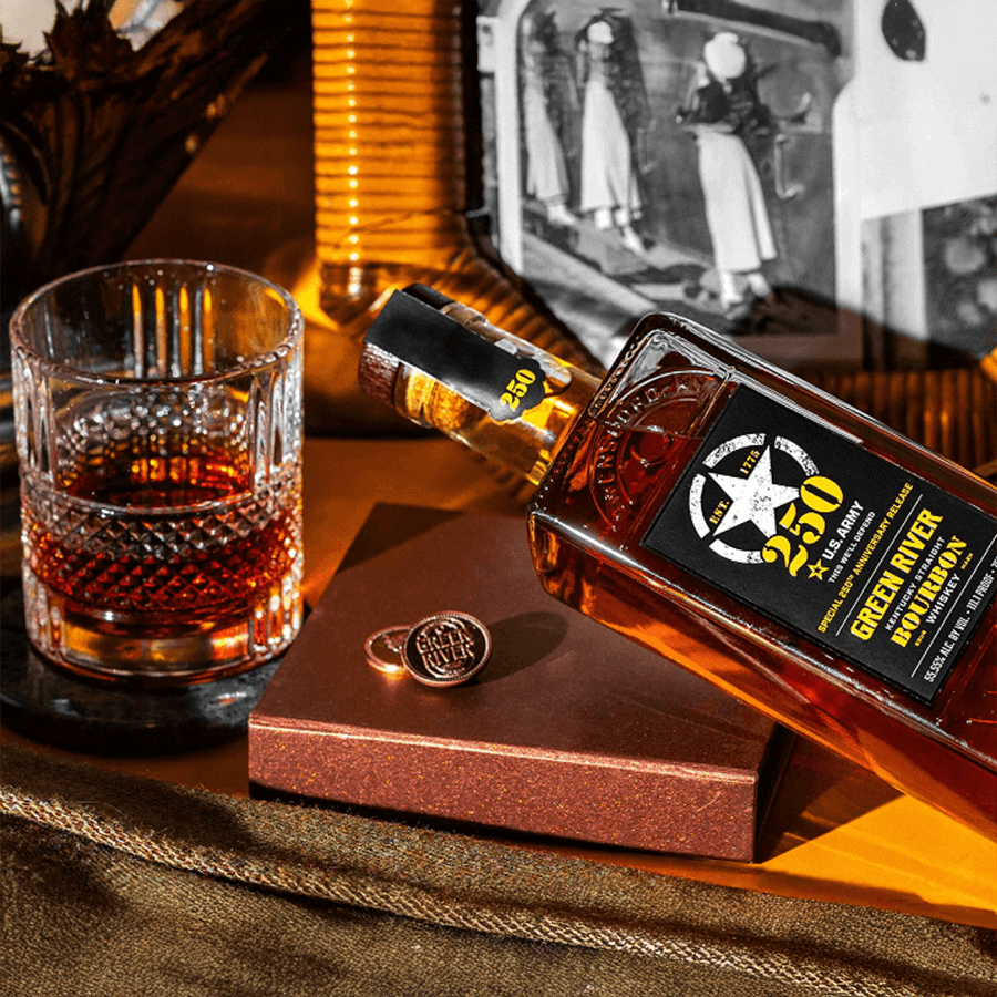 Green River 250th Anniversary bourbon bottle with glass and coasters on a decorative table.