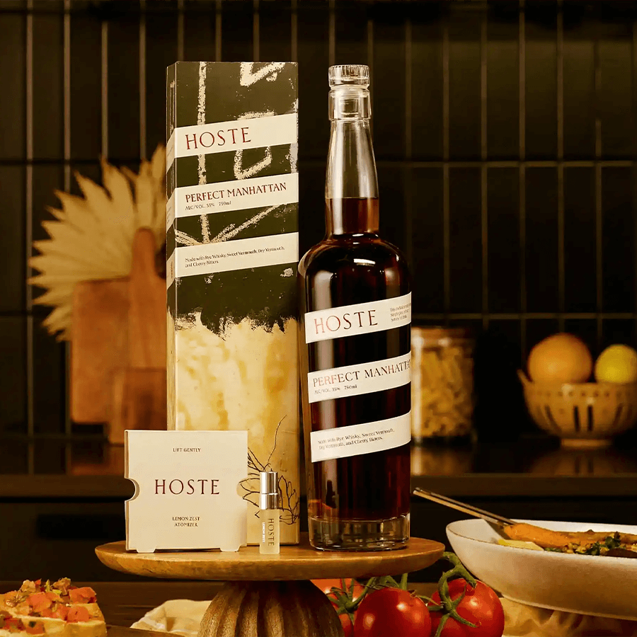 Hoste Perfect Manhattan Cocktail bottle with custom vermouths and bitters, elegantly displayed in a kitchen setting.