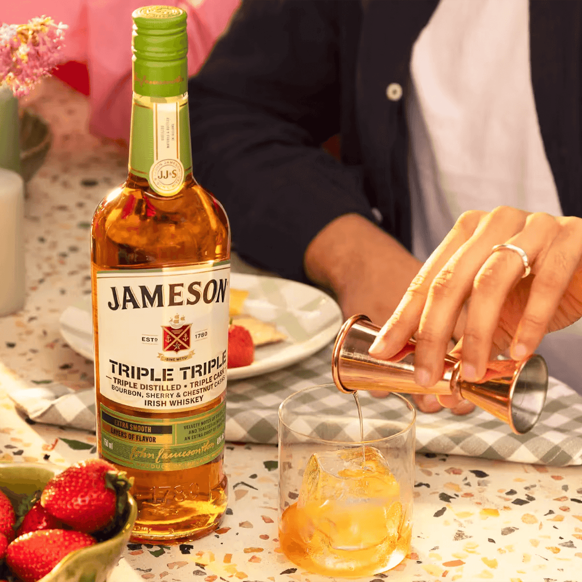 Jameson Triple Triple Irish Whiskey bottle with a cocktail glass, showcasing smoothness and rich flavors.