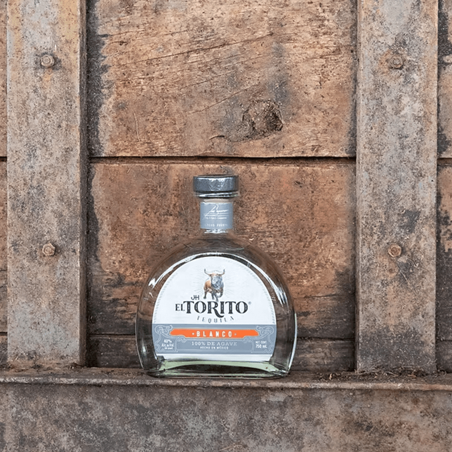 Jh El Torito Blanco Tequila bottle on a rustic wooden background, showcasing artisanal craftsmanship and authentic flavor.