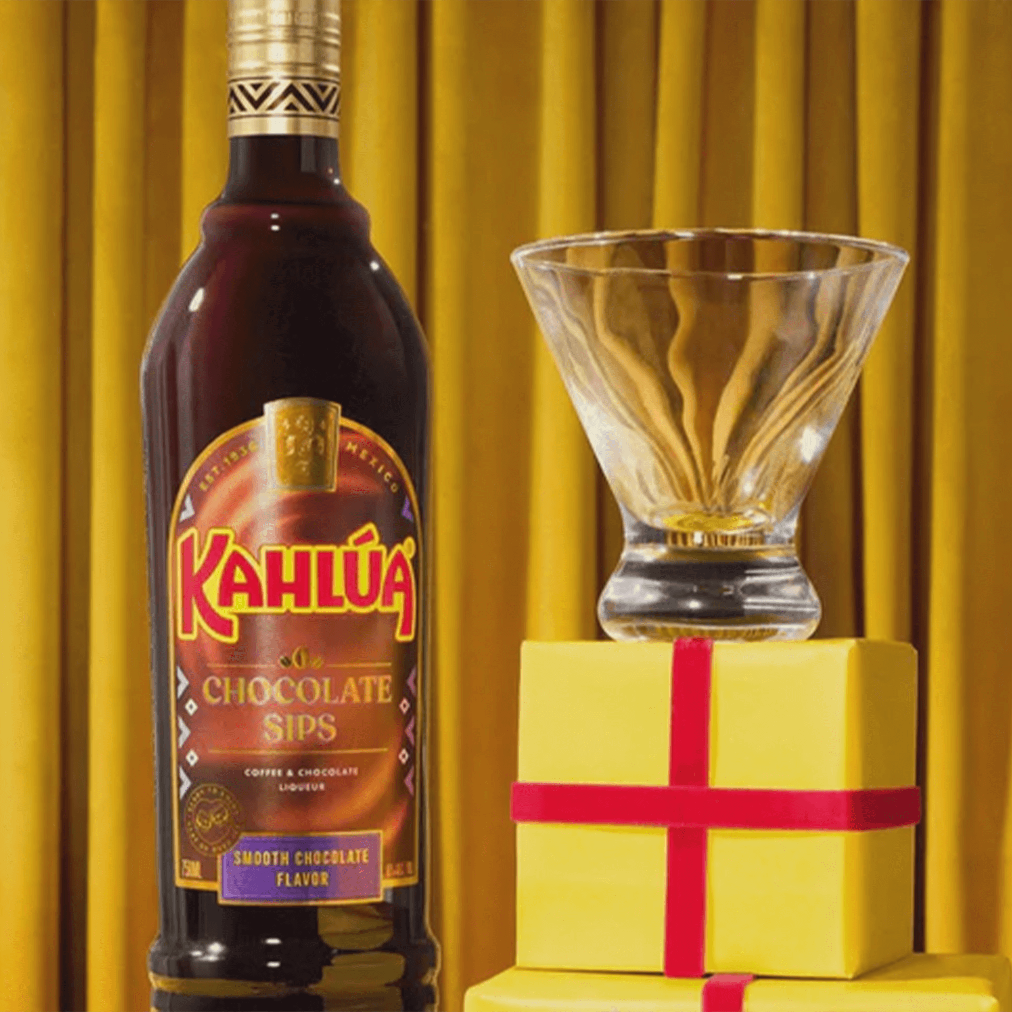 Kahlúa Chocolate Sips bottle with glass and gift boxes, showcasing rich coffee and chocolate liqueur.