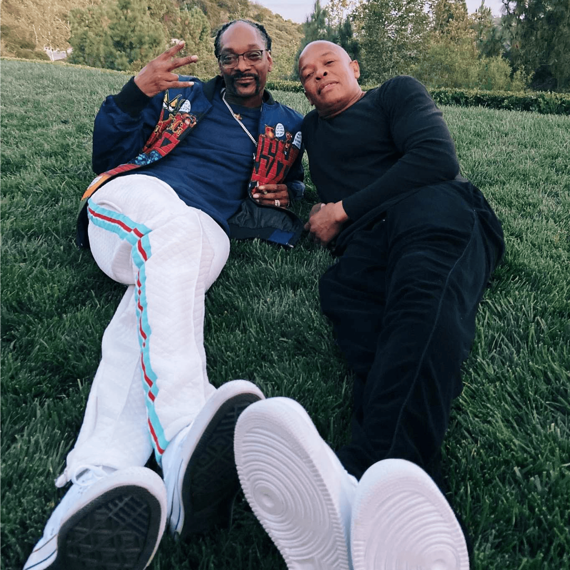 Dr. Dre and Snoop Dogg lounging outdoors, promoting their ultra-premium Still G.I.N. gin brand.