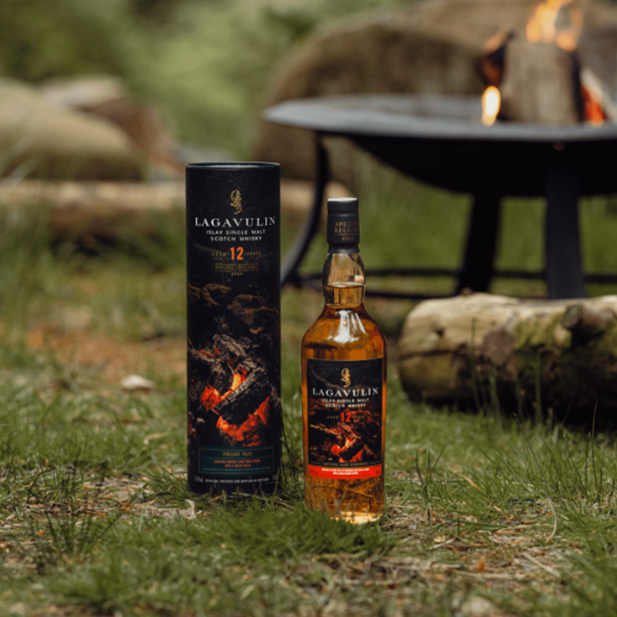 Lagavulin 12 Year Fireside Tales Single Malt Whisky bottle with packaging, set outdoors by a campfire.