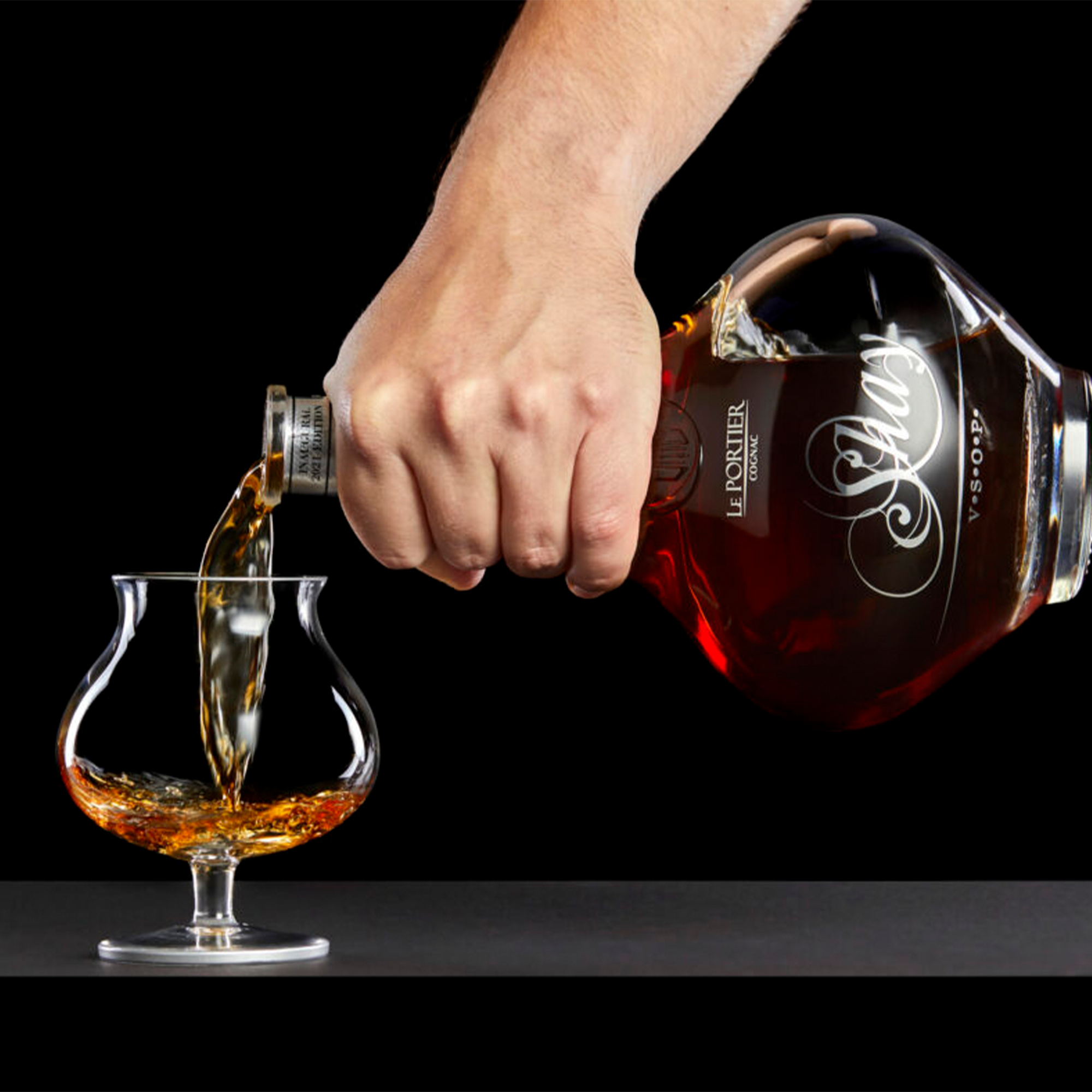 Pouring Le Portier Shay VSOP Cognac into a glass, showcasing rich amber color and elegance.