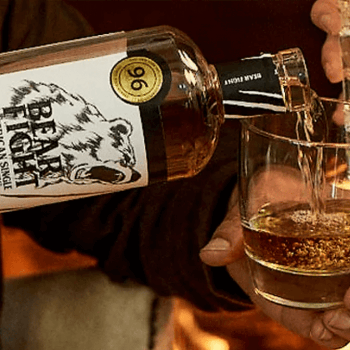 Pouring Bear Fight American Single Malt Whiskey into a glass, showcasing its rich color and bold flavor.