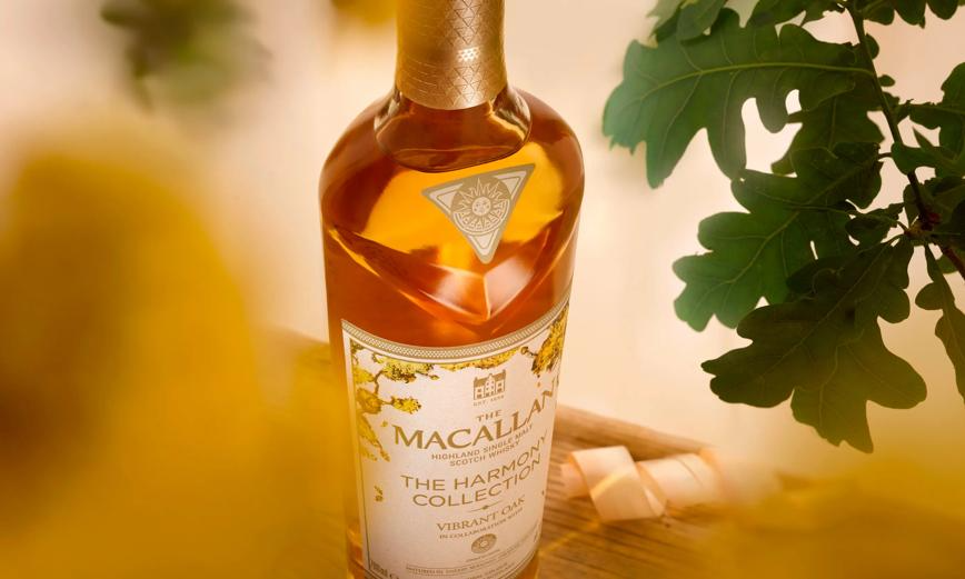 Macallan Harmony Collection Vibrant Oak Single Malt Scotch whisky bottle with oak leaves in a soft focus background.