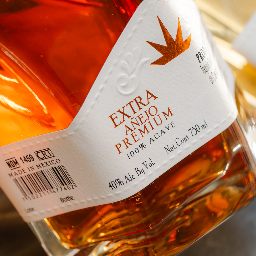 Mundo De Oro Añejo tequila bottle showcasing its rich color and premium label.