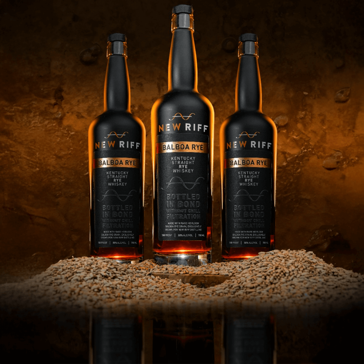 Three New Riff Balboa Rye Whiskey bottles displayed with rye grains, showcasing specialty whiskey craftsmanship.