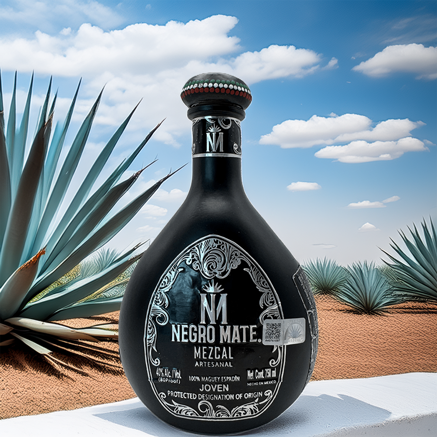 Negro Mate Pintada mezcal bottle against a desert backdrop with agave plants and a bright blue sky.