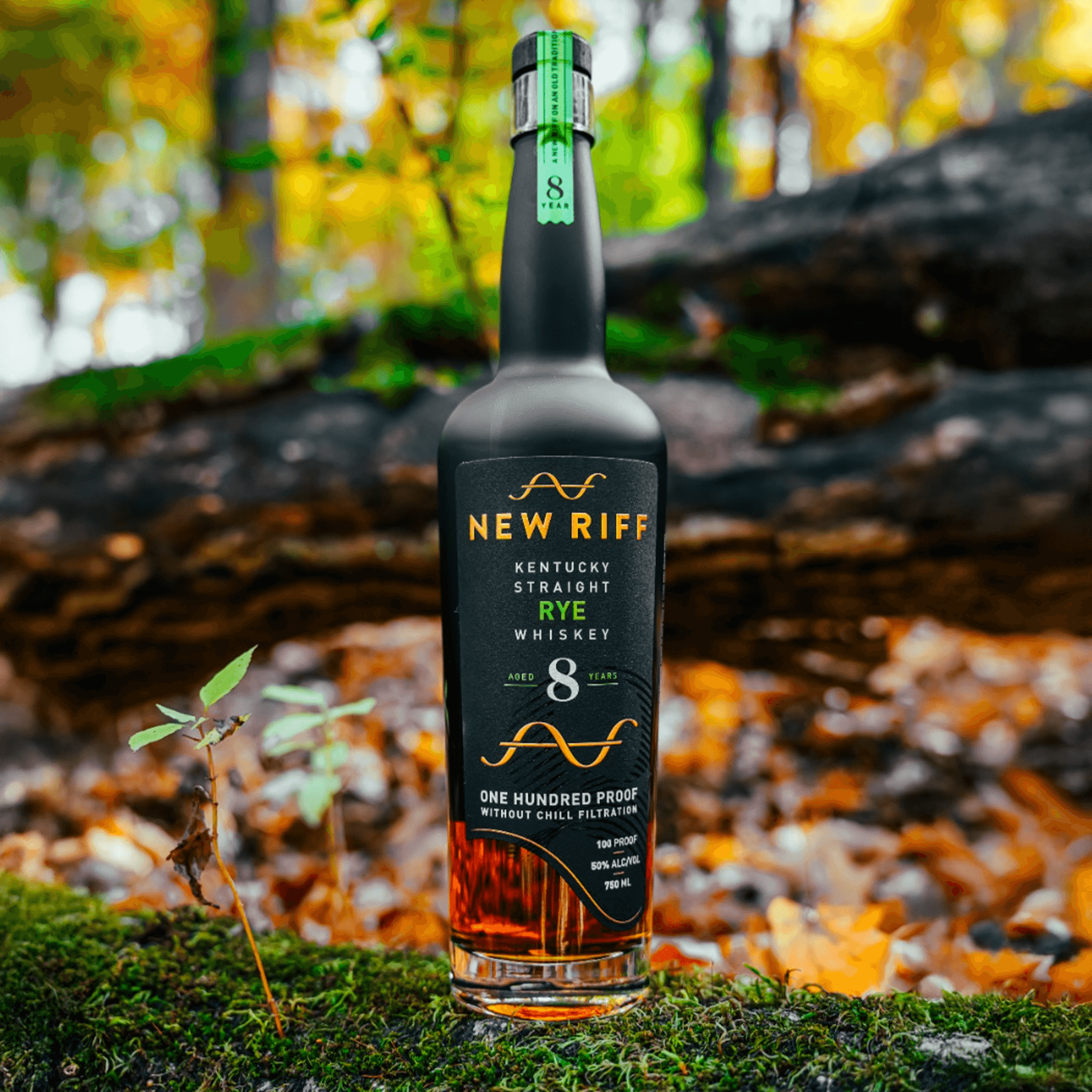New Riff 8 Year Rye Whiskey bottle surrounded by autumn leaves, showcasing rich amber color and unique label design.