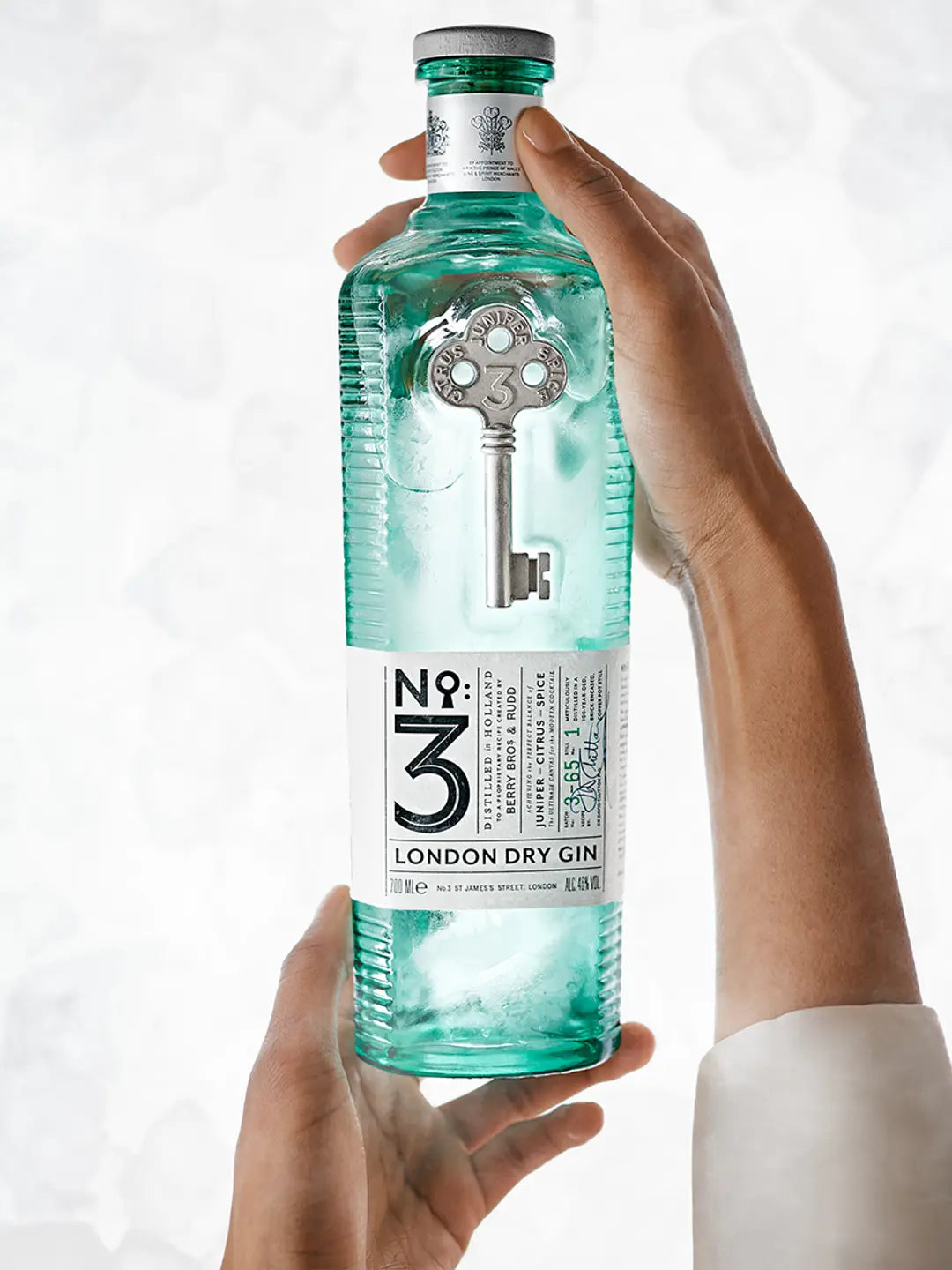 No 3 London Dry Gin bottle held by hand, showcasing its unique design and luxury craftsmanship.