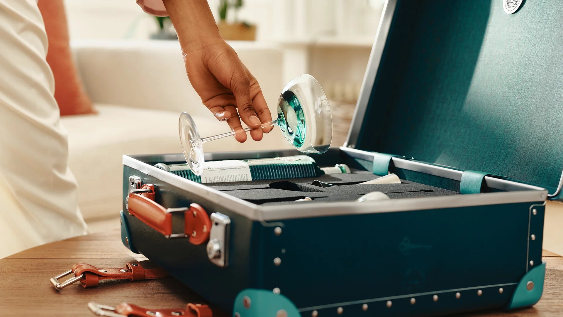 Hand placing a martini glass into the No 3 London Dry Gin Globe Trotter Martini case.