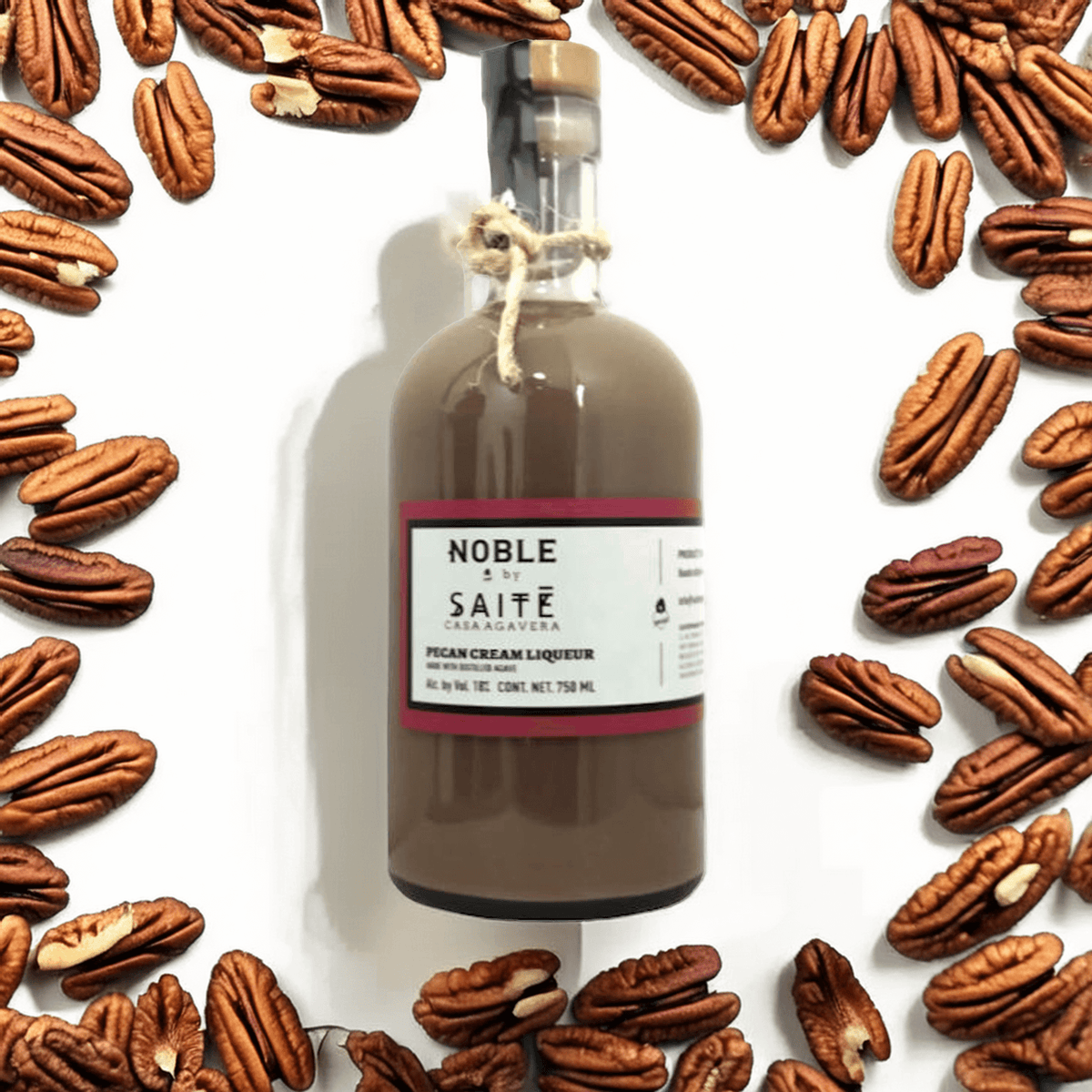 Noble by Saite Pecan Cream Liqueur surrounded by roasted pecans, highlighting its rich, creamy texture and flavors.