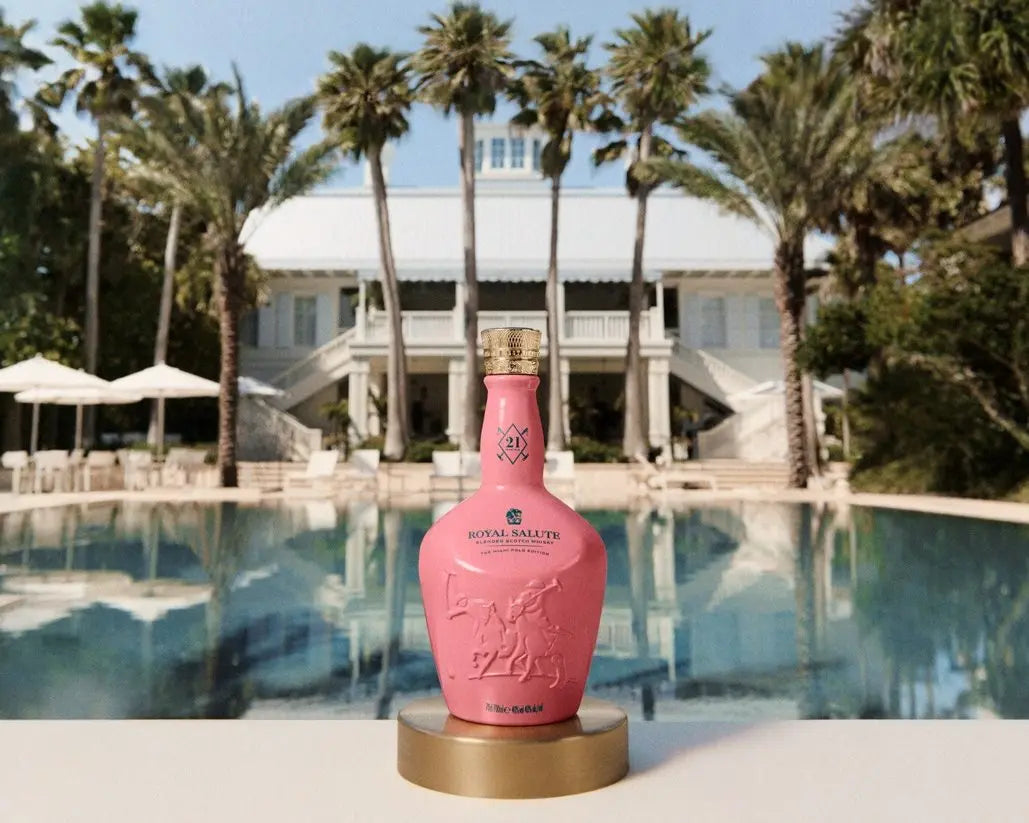 Royal Salute The Miami Polo Edition whisky in front of a luxury poolside setting with palm trees.