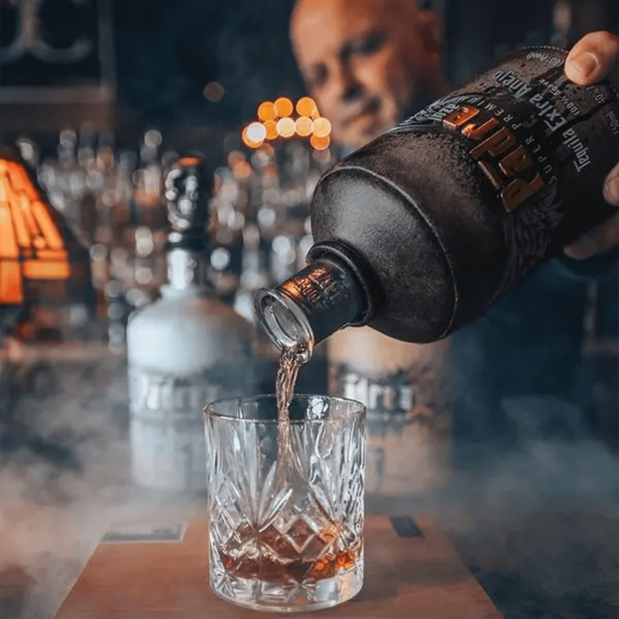 Pouring Padre Azul Extra Añejo tequila into a crystal glass, showcasing its rich golden color and premium quality.