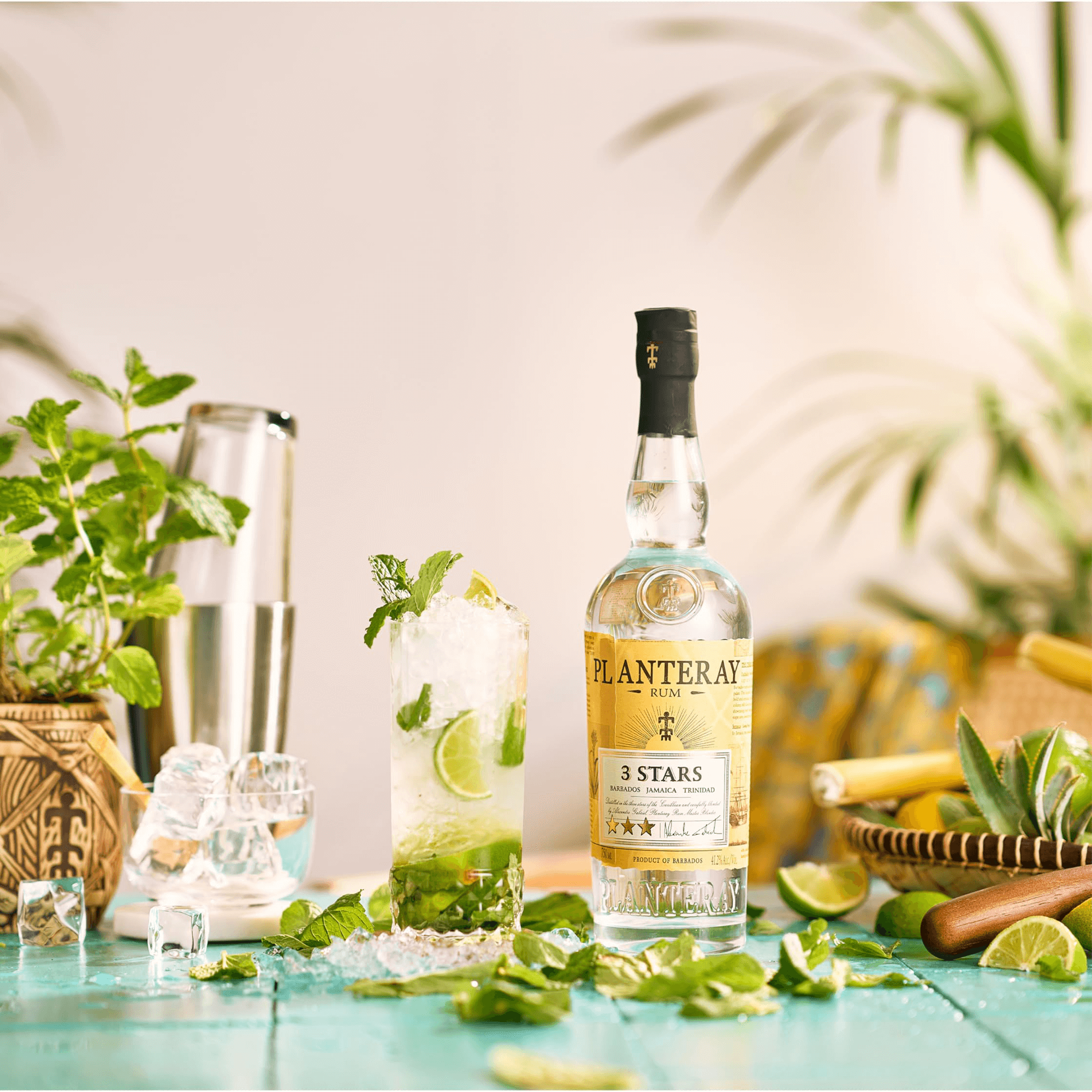 Planteray 3 Stars White Rum bottle with a refreshing cocktail and fresh mint on a colorful tropical backdrop.