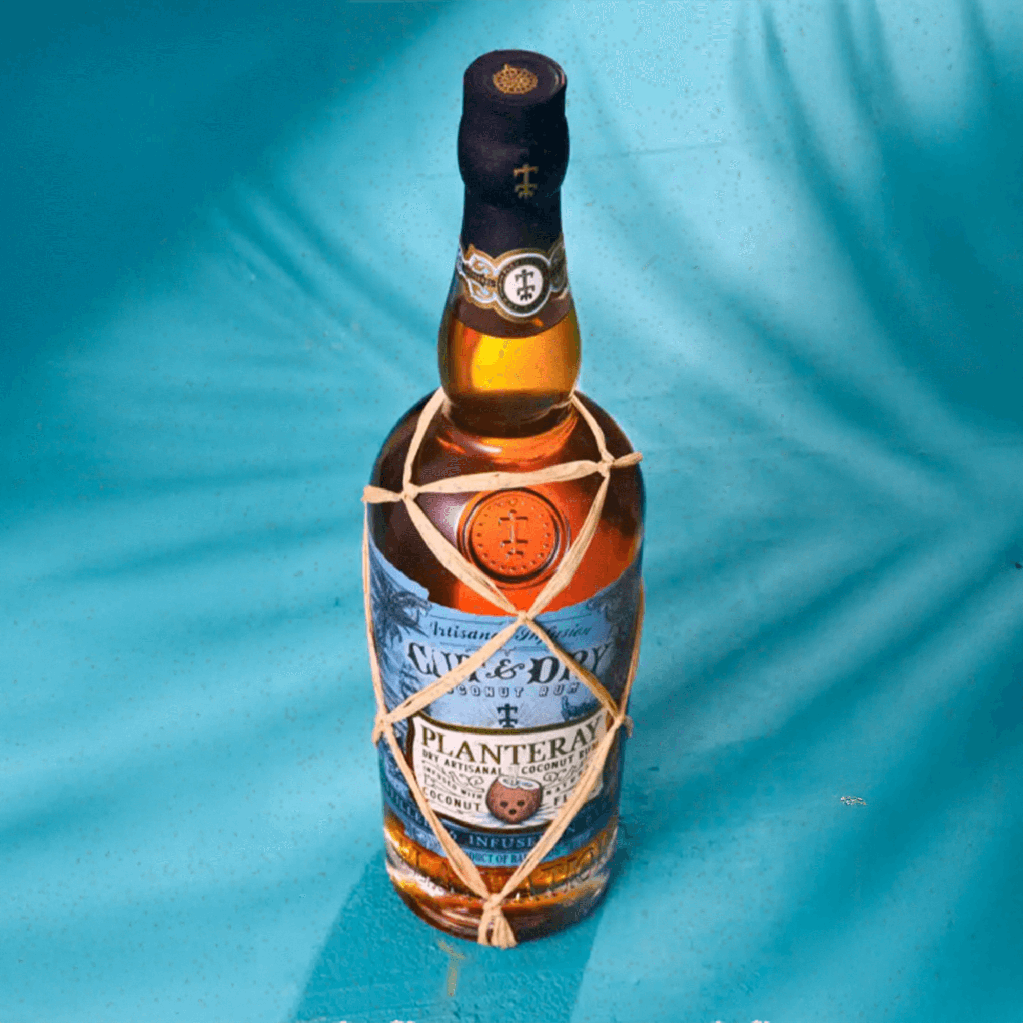 Planteray Cut & Dry Coconut Rum 700ml with artisanal coconut and rum blend on a vibrant blue background.