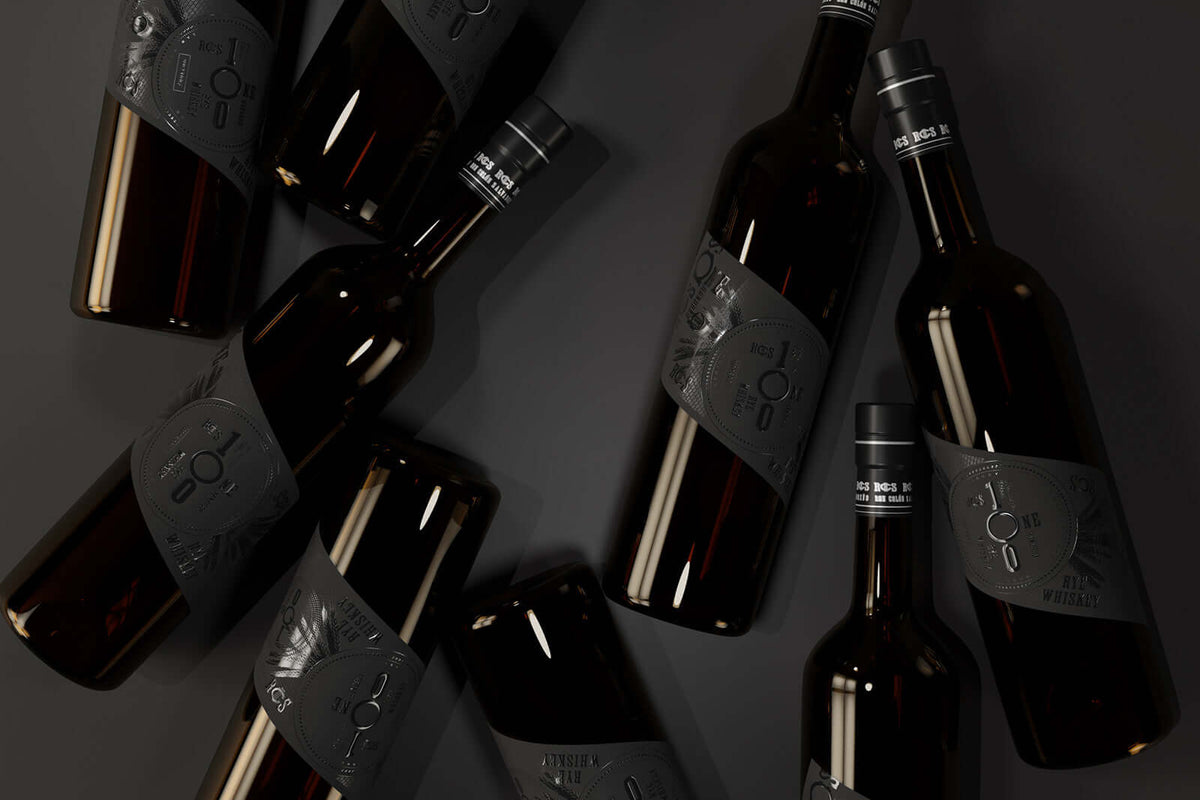 Ron Colón Salvadoreño American Rye Whiskey bottles arranged on a dark surface, showcasing elegant black labels.