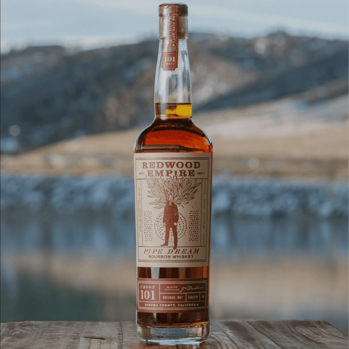 Bottle of Redwood Empire Pipe Dream 101 Proof bourbon whiskey with scenic background.