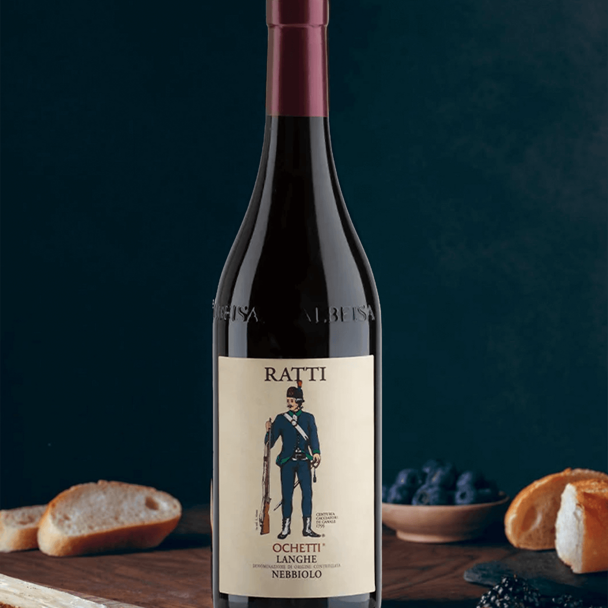 Renato Ratti Ochetti Langhe Nebbiolo DOC 2022 wine bottle with bread and berries on a dark background.